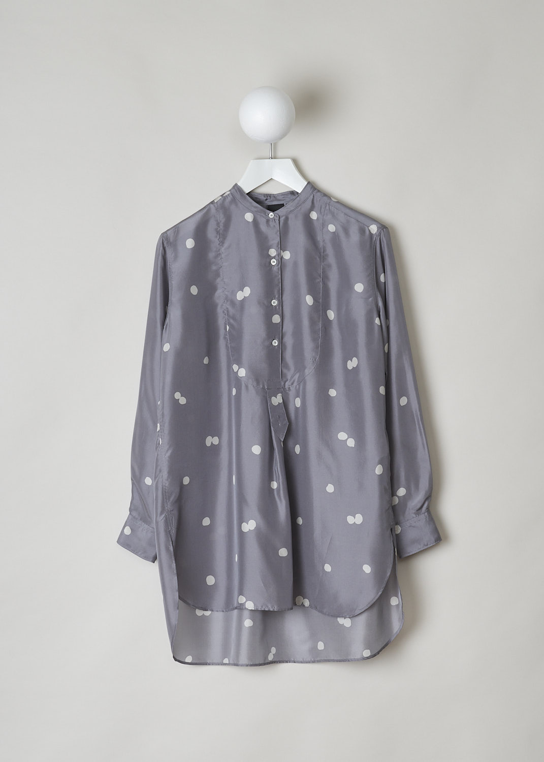 ASPESI, GREY LONG SLEEVE BLOUSE WITH DOTTED PRINT, 5441_M278_62187, Grey, Print, Silver, Front, This grey silk blouse has a pale grey dotted print. The blouse has a mandarin collar with a four button closure down the front. The long sleeves have buttoned cuffs. In the back, along the back yoke, crystal pleats drape the fabric. The blouse has a rounded hemline with an asymmetrical finish, meaning the back is longer than the front. 
