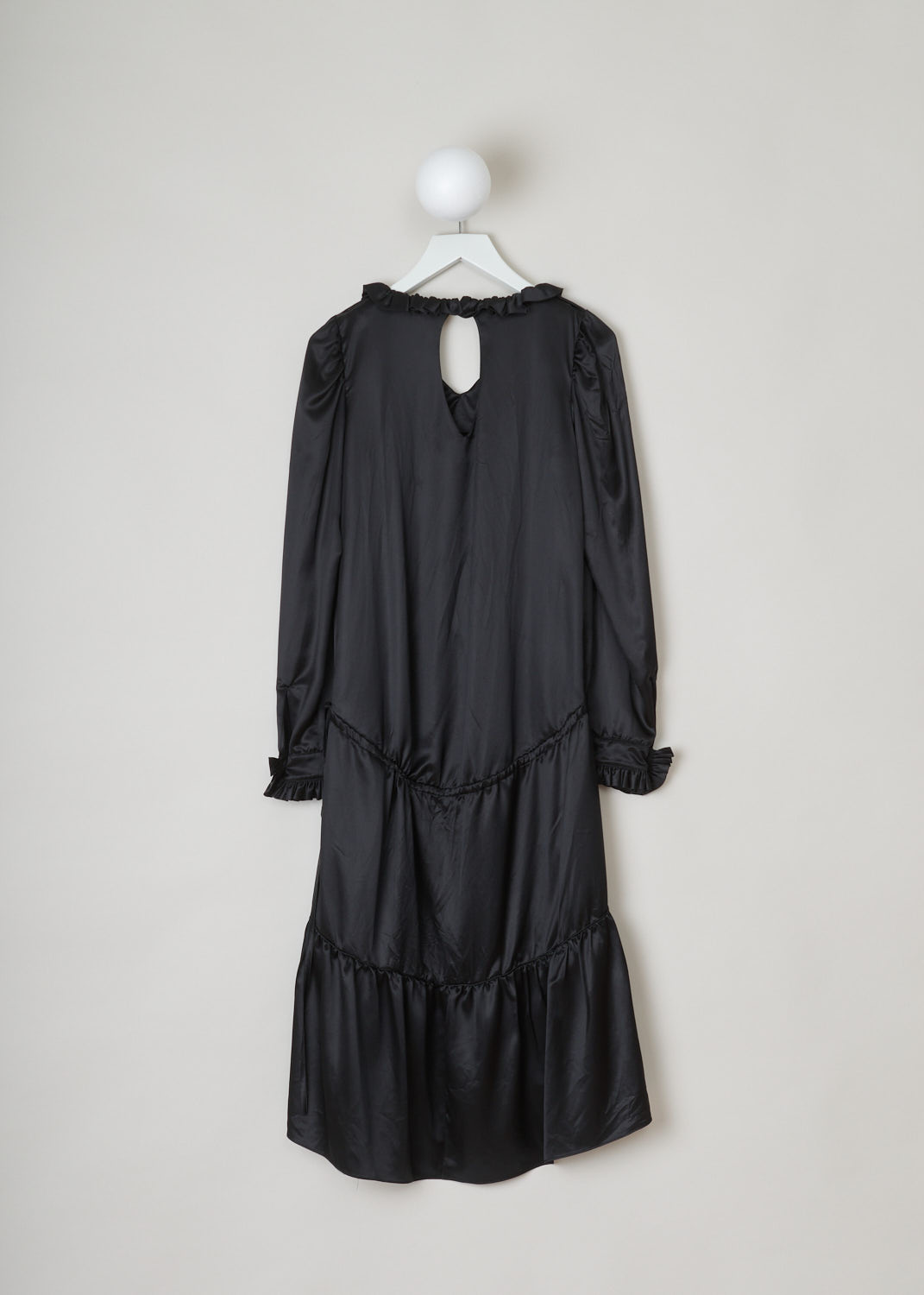 Balenciaga, Black ruffled dress, 494197_TXC02_1000, black, back. This all black dress has a ruffled neckline and cuffs which have a single button. A cord tunnel divides the skirt from the top. The closure option on this piece is the single button on the back.