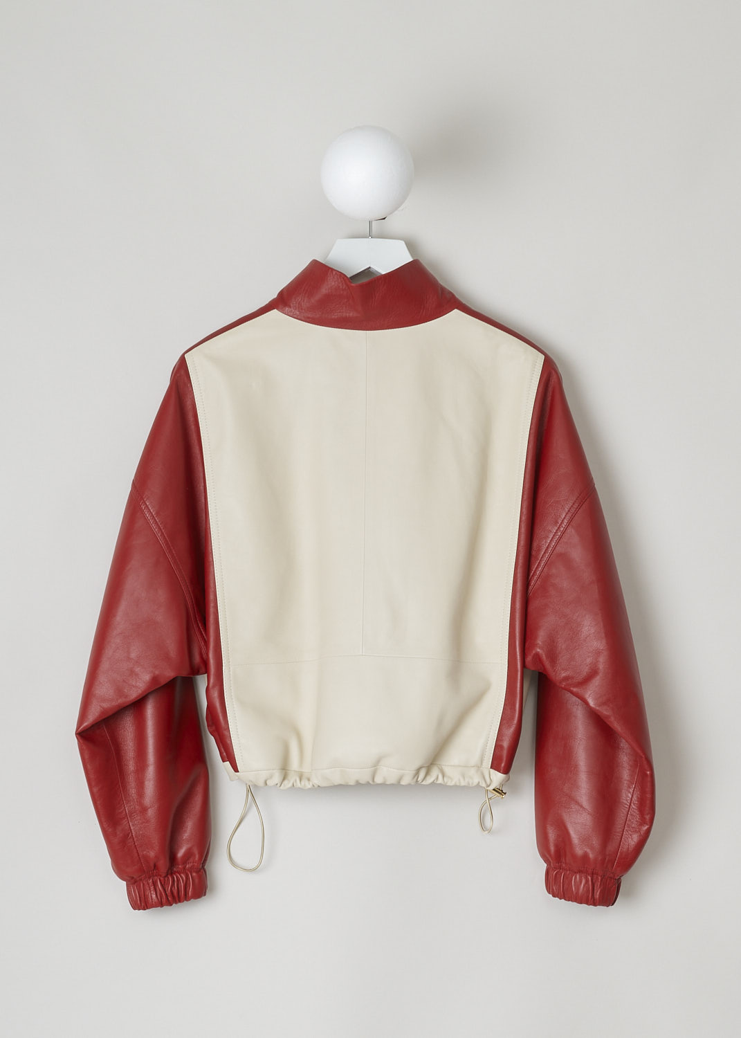 CELINE, TWO-TONE CROPPED LEATHER JACKET, 150T_2EE13_27LV, Red, Beige, Back, This cropped leather jacket is  two-toned, with the top half in lipstick red and the bottom half and the back in off-white. The jacket has a stand-up collar, two patch pockets with flap and a zipper in a matching off-white color. The gold-tone pull-tab is shaped in the brand's logo. The long sleeves have elasticated cuffs. The elasticated hemline has gold-tone cord locks on the inside. The jackets has a single inner pocket

