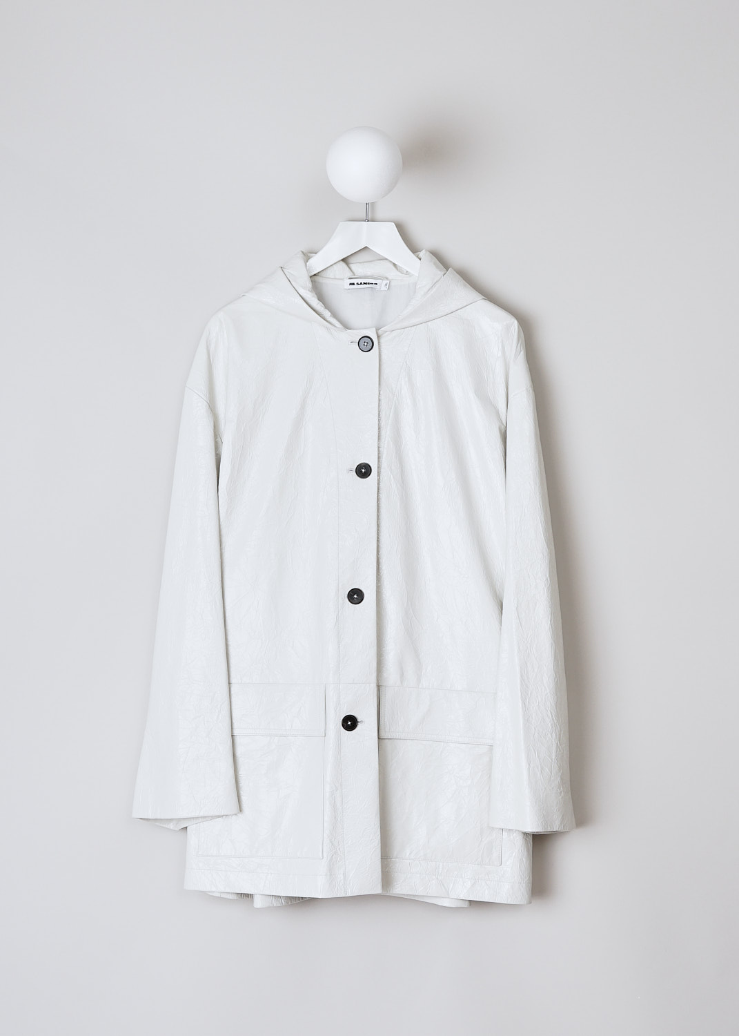 JIL SANDER, WHITE CRACKLED LEATHER COAT WITH HOOD, JSPN654170_WNL00080_105, White, Front, This hooded coat is made of a off-white crackled leather. The coat has a front button closure with brown buttons. On the front, the coat has two flap patch pockets. The coat has a straight hemline.  
