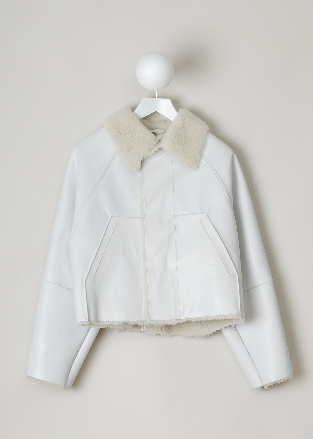 KASSL, CROPPED SHEARLING OIL WHITE COAT, C11310000W_COAT_ORIGINAL_CROPPED_SHEARLING_OIL_WHITE, White, Front, This cropped coat is made with the brand's signature oil coated cotton-blend in white and is fully lined with shearling. The coat has a shearling spread collar, magnetic front button closure and slanted pockets. The coat is constructed with different seams, giving it a paneled look. 
