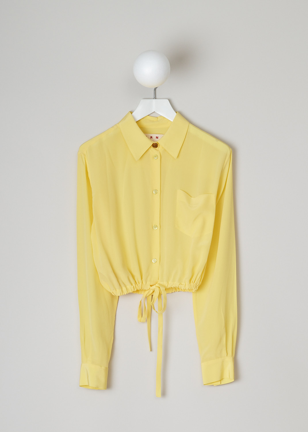 MARNI, LEMON YELLOW SILK CRÊPE DE CHINE BLOUSE, CAMA0526A0_UTSF72_00Y20, Yellow, Front, This cropped silk crêpe de Chine blouse in lemon yellow has a pointed collar and a front button closure, with a bronze-colored top button. The long sleeves cuffs with those same bronze-colored buttons. In the front, the blouse has a single breast pocket. The hemline has a drawstring. 
  

