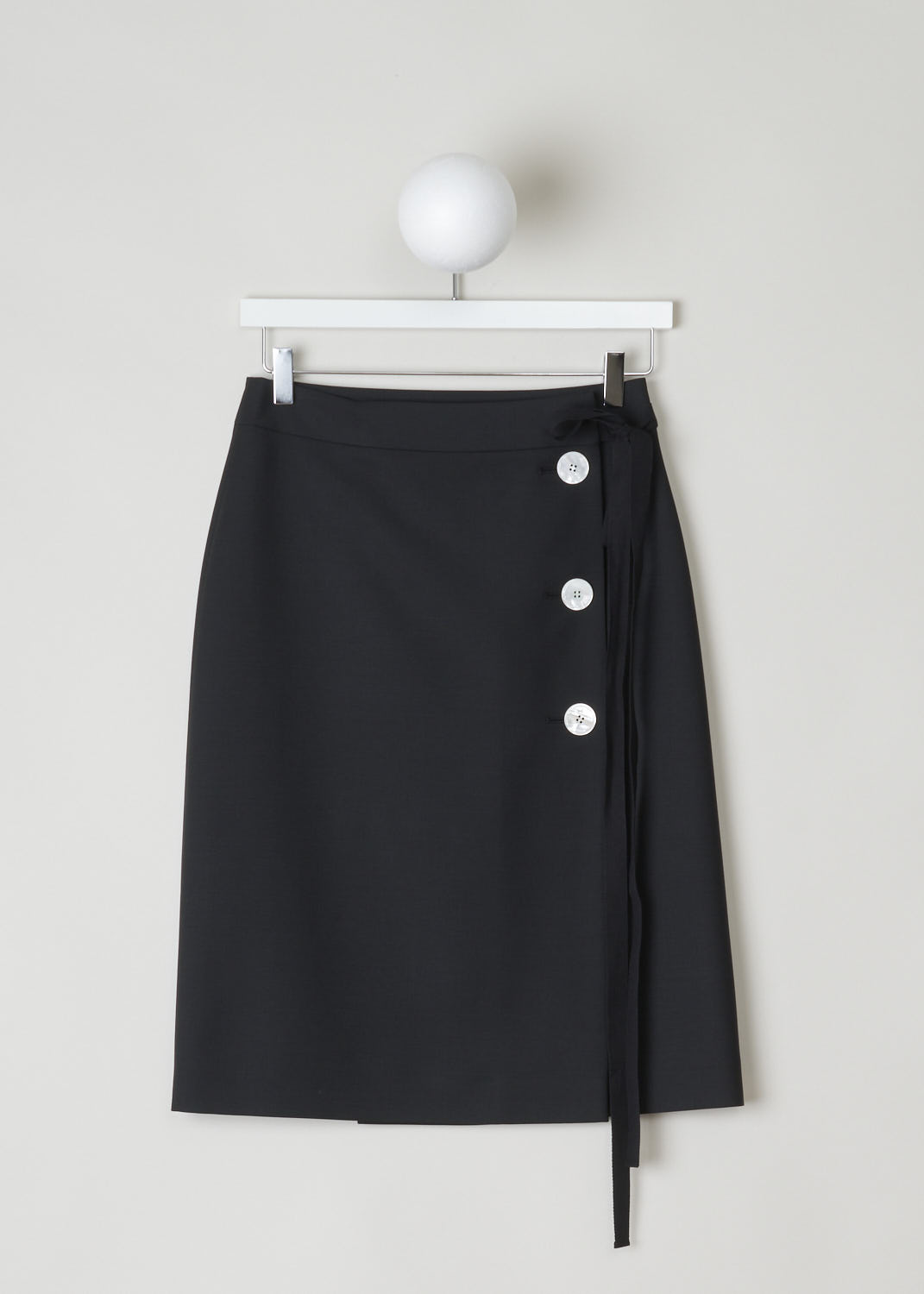 PRADA, BLACK WRAP SKIRT WITH BUTTONS AND TIE DETAIL, 
KID_MOHAIR_P122R_NERO, Black, Front, Black wrap skirt with three contrasting mother-of-pearl buttons on the side. Above the buttons, a black ribbon tie detail can be found. Both the buttons and the tie function as the closure option, as well as a concealed button and hook on the inside. 