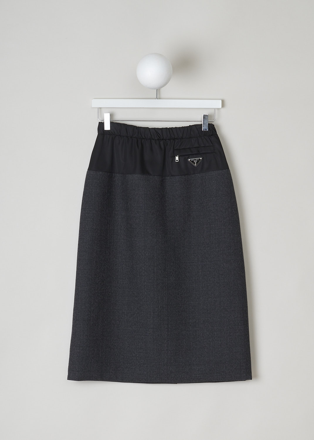 PRADA, MULTI FABRIC PENCIL SKIRT, P198S_1Y34_F0806_GALLES_RE_NYLON, Black, Grey, Print, Front, This multi fabric pencil skirt has a black upper trim and a heather grey checkered lower part. The skirt has an elasticated waistband with drawstrings on the inside to cinch in the waist. A concealed side zip functions as an additional closure option. A zipped welt pocket can be found on the front with below, the brand's silver and black triangle logo plaque. In the back, the skirt has a centre slit. The skirt has a straight hemline.
