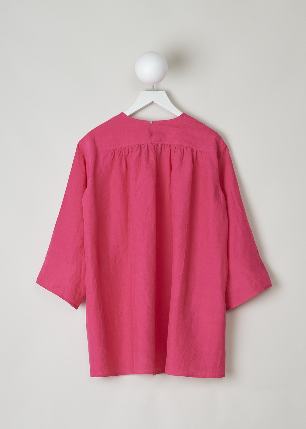SOFIE Dâ€™HOORE, FUCHSIA COLORED BINETTE TOP, BINETTE_LIFE_FUCHSIA, Pink, Back, This oversized fuchsia top features a round neckline, dropped shoulders and long sleeves. The A-line top has a square bib-like front with pleated details below. Concealed in the side seams, slanted pockets can be found. The top has an asymmetrical finish, meaning the back is a little longer than the front. 

