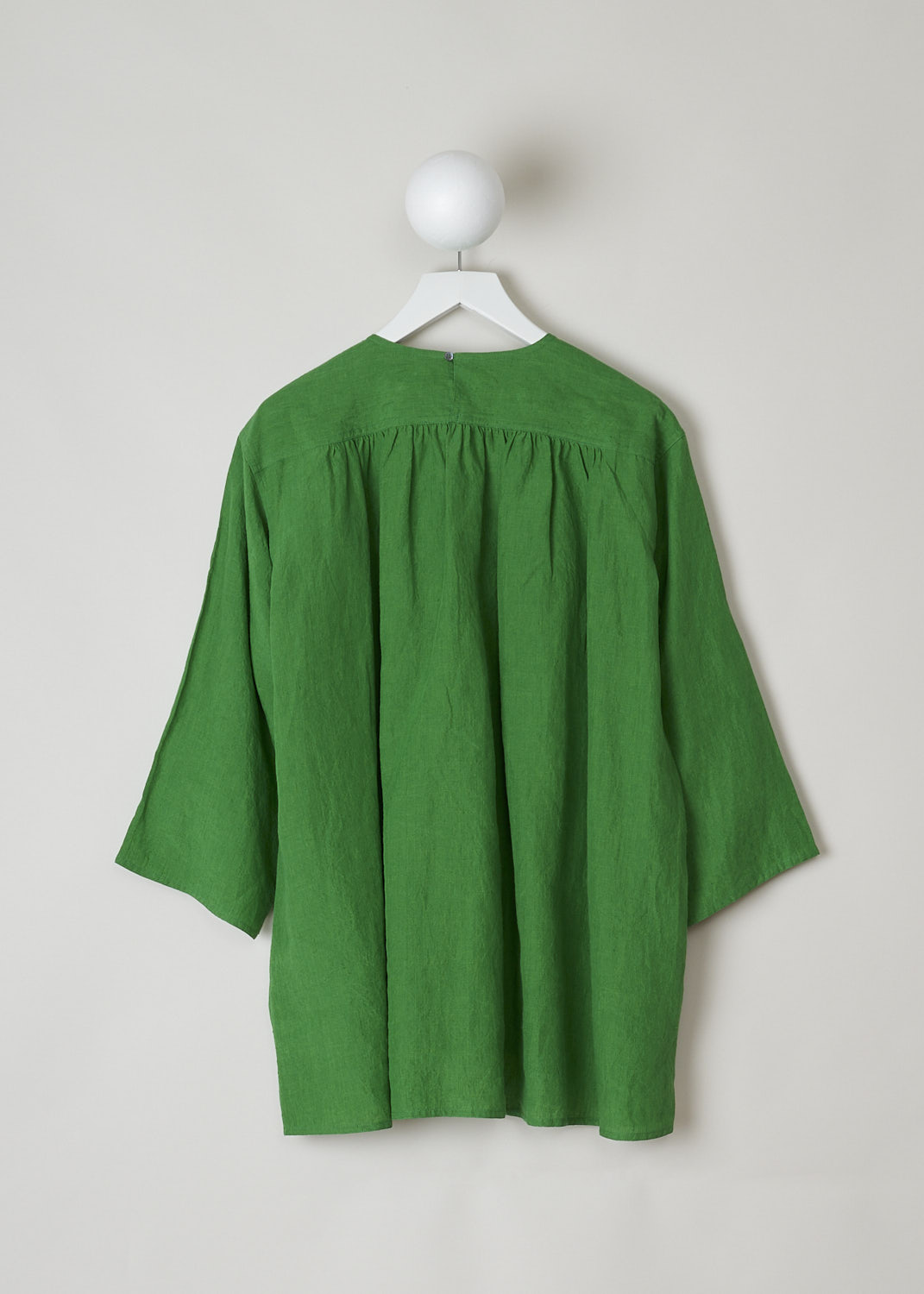 SOFIE Dâ€™HOORE, BRIGHT GREEN BINETTE TOP, BINETTE_LIFE_GRASS, Green, Back, This oversized bright green top features a round neckline, dropped shoulders and long sleeves. The A-line top has a square bib-like front with pleated details below. Concealed in the side seams, slanted pockets can be found. The top has an asymmetrical finish, meaning the back is a little longer than the front. 

