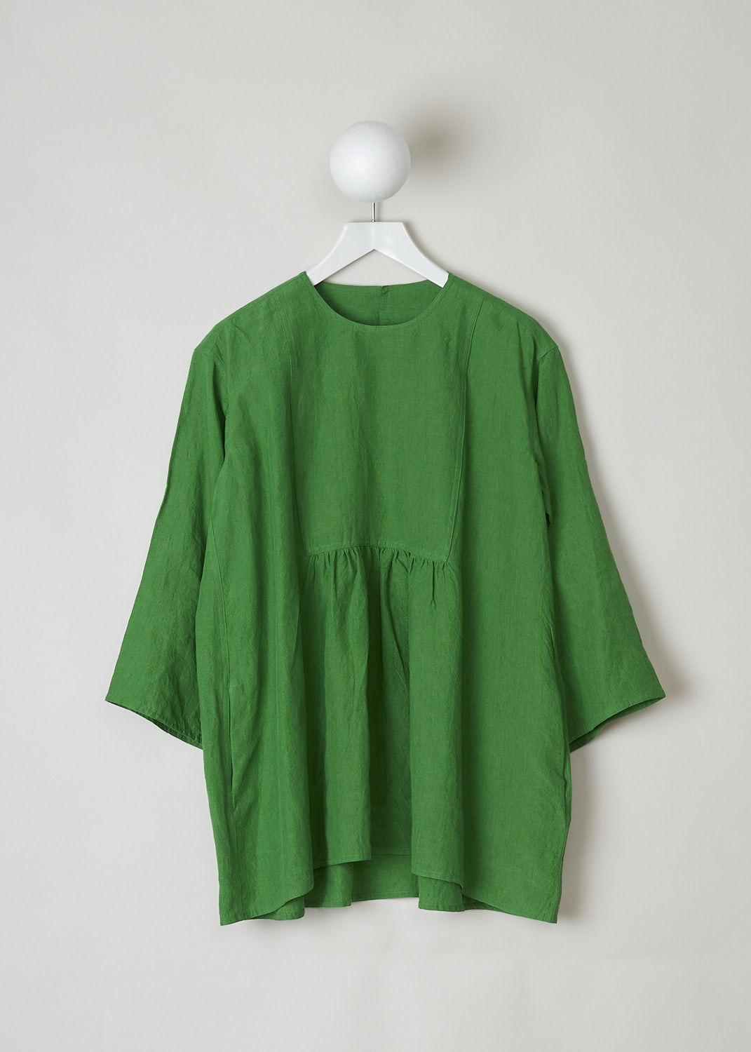 SOFIE Dâ€™HOORE, BRIGHT GREEN BINETTE TOP, BINETTE_LIFE_GRASS, Green, Front, This oversized bright green top features a round neckline, dropped shoulders and long sleeves. The A-line top has a square bib-like front with pleated details below. Concealed in the side seams, slanted pockets can be found. The top has an asymmetrical finish, meaning the back is a little longer than the front. 

