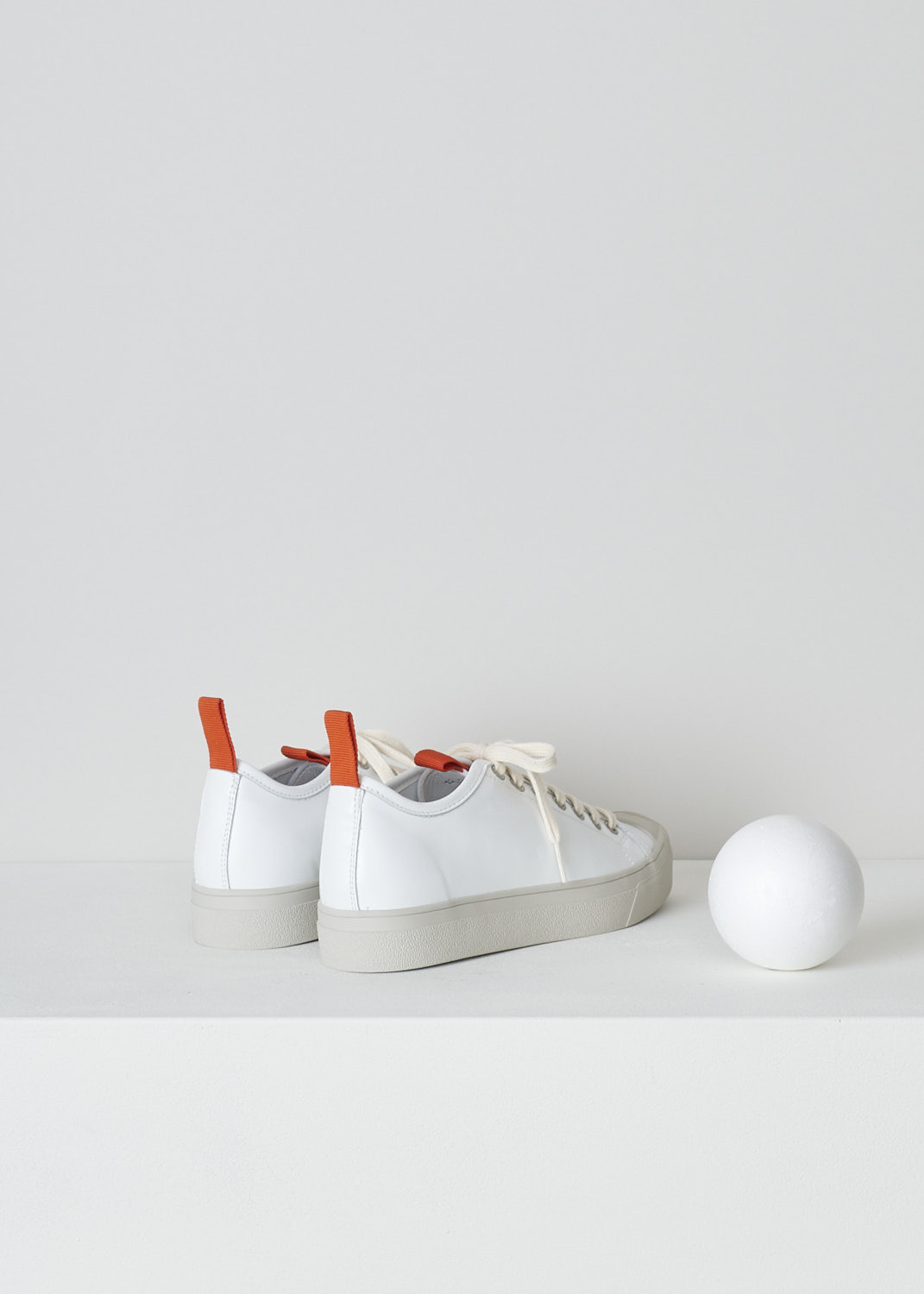 SOFIE Dâ€™HOORE, WHITE LEATHER SNEAKERS WITH RED ACCENTS, FABLE_LCOL_WHCL, White, Back, These white leather sneakers feature a front lace-up closure with white laces. Red pull-tabs can be found on the back of the heel and on the front of the tongue. These sneakers have a round toe with a beige rubber toe cap that goes down into the rubber sole in that same beige color. 

