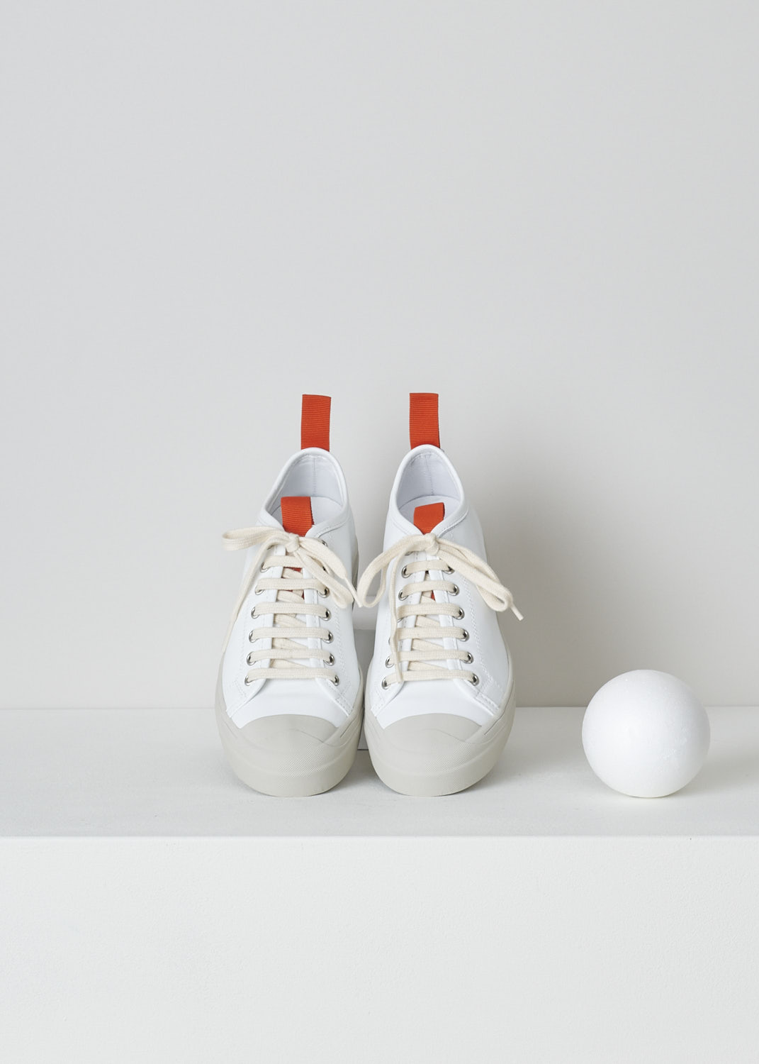 SOFIE Dâ€™HOORE, WHITE LEATHER SNEAKERS WITH RED ACCENTS, FABLE_LCOL_WHCL, White, Top, These white leather sneakers feature a front lace-up closure with white laces. Red pull-tabs can be found on the back of the heel and on the front of the tongue. These sneakers have a round toe with a beige rubber toe cap that goes down into the rubber sole in that same beige color. 

