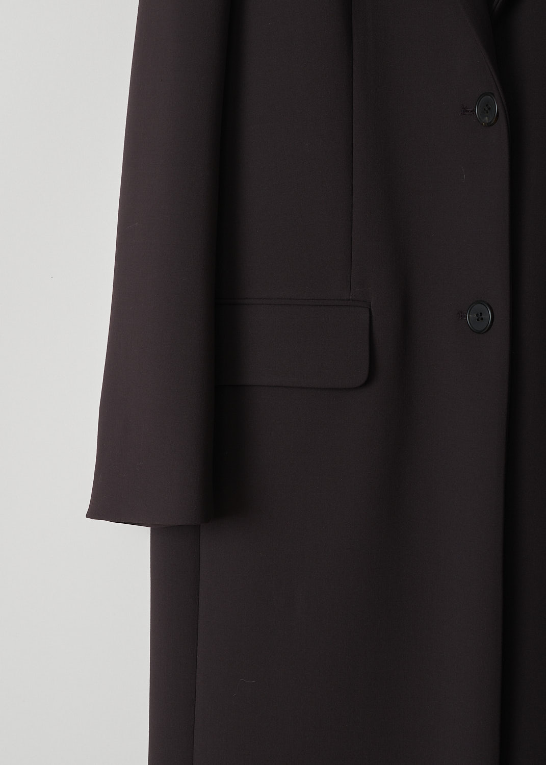 THE ROW, DUSTOVA COAT IN COFFEE, DUSTOVA_COAT_5869W21_18_COFFEE, Brown, Detail, This Coffee brown Dustova coat has a peaked lapel with a deep V and a front button closure. The long sleeves have buttoned cuffs. In the front, the coat has flap welt pockets. In the back, the coat has a single centre vent. 

