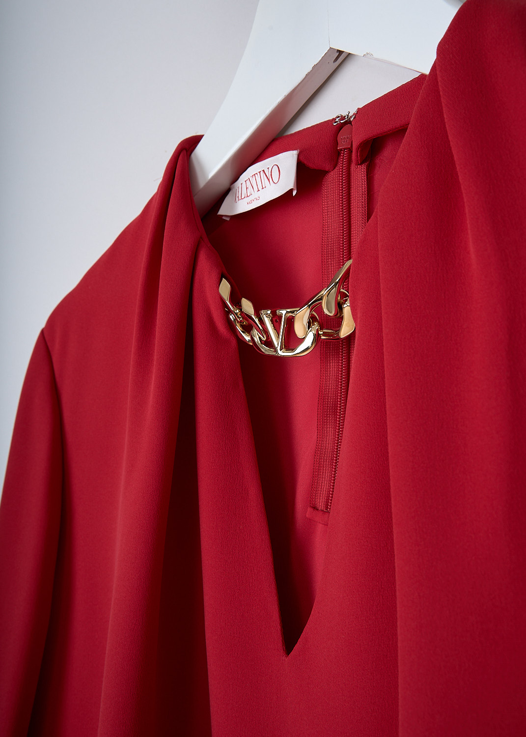 VALENTINO, RED SILK TOP WITH GOLD-TONE CHAIN DETAIL, 1B3AE7551MM_157, Red, Detail, This red silk top has a V-neckline with a gold-tone V-logo chain. The top has long balloon sleeves with pleated cuffs with a single button. In the back, the dress has a concealed centre zip. The dress has a straight hemline. 
