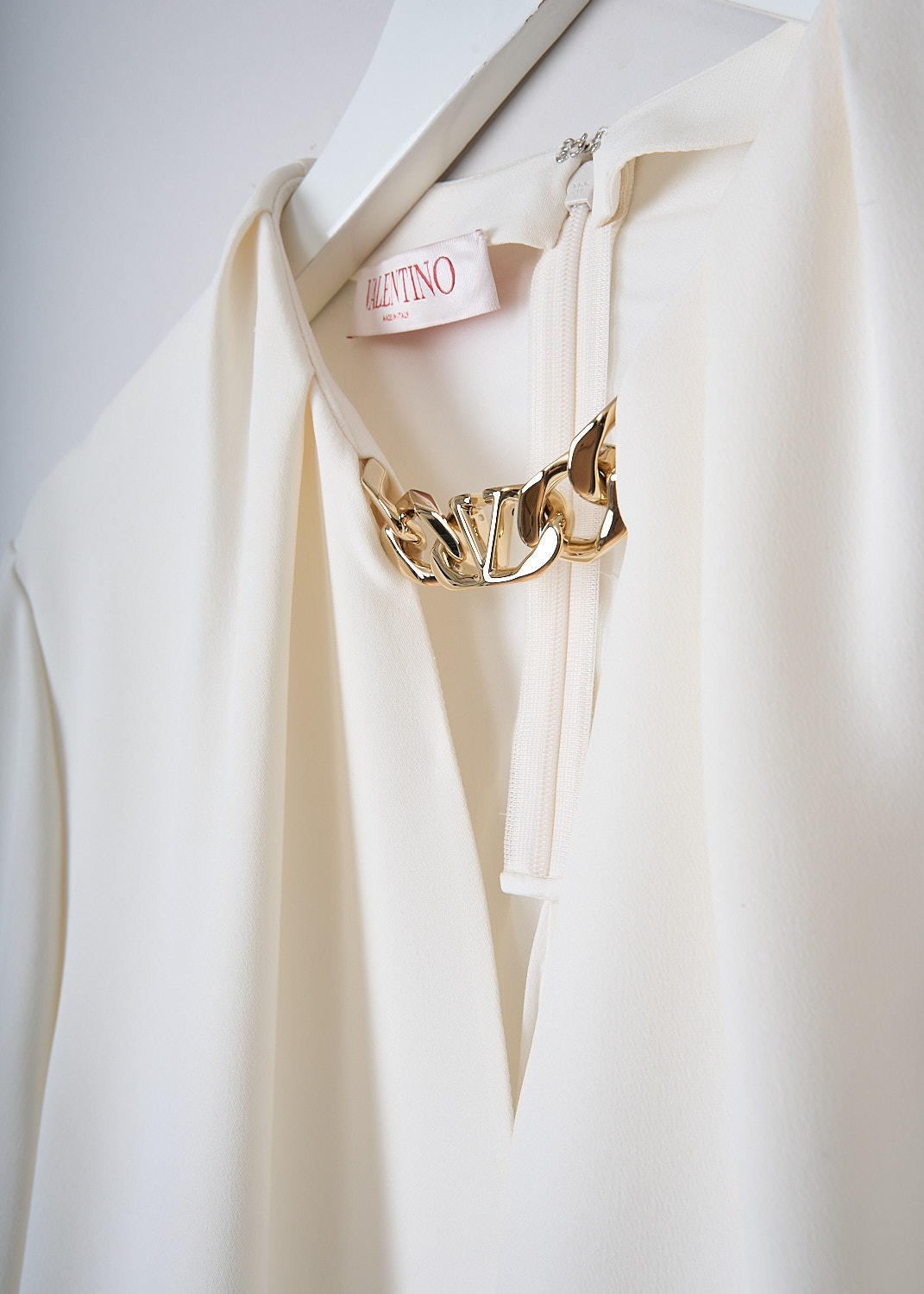 VALENTINO, WHITE SILK TOP WITH GOLD-TONE CHAIN DETAIL, 1B3AE7551MM_A03, White, Detail, This white silk top has a V-neckline with a gold-tone V-logo chain. The top has long balloon sleeves with pleated cuffs with a single button. In the back, the dress has a concealed centre zip. The dress has a straight hemline.  
