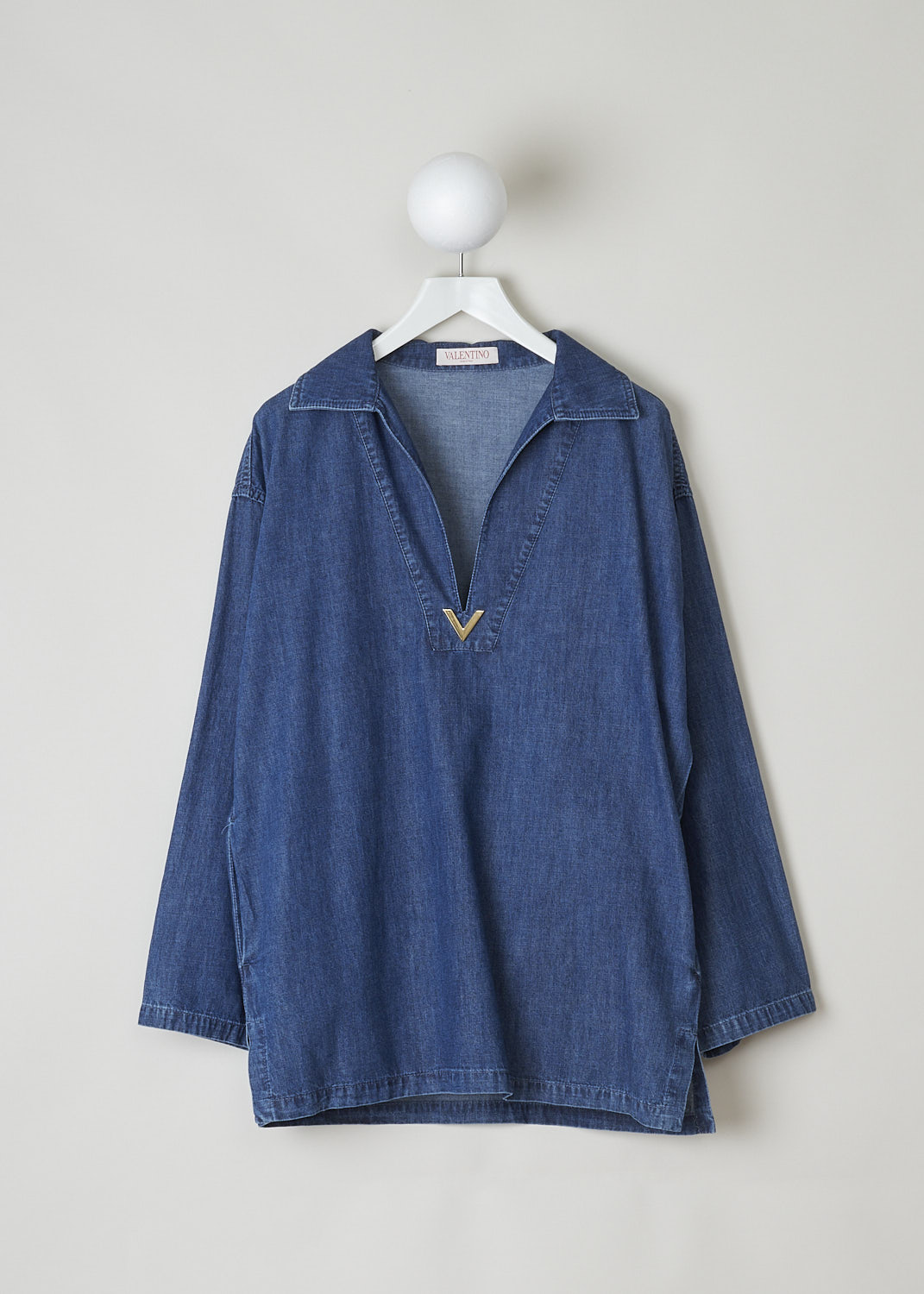 VALENTINO, DARK WASH DENIM TOP WITH DEEP V, 2B3DB01Z7MR_558, Blue, Front, This wide long sleeve top in a dark wash jean fabric has a spread collar with a deep V-neckline. The end of the V-neck is decorated with the brands signature V. Slanted pockets are concealed in the side seams. The top has a straight hemline. Small slits can be found on either side. 
