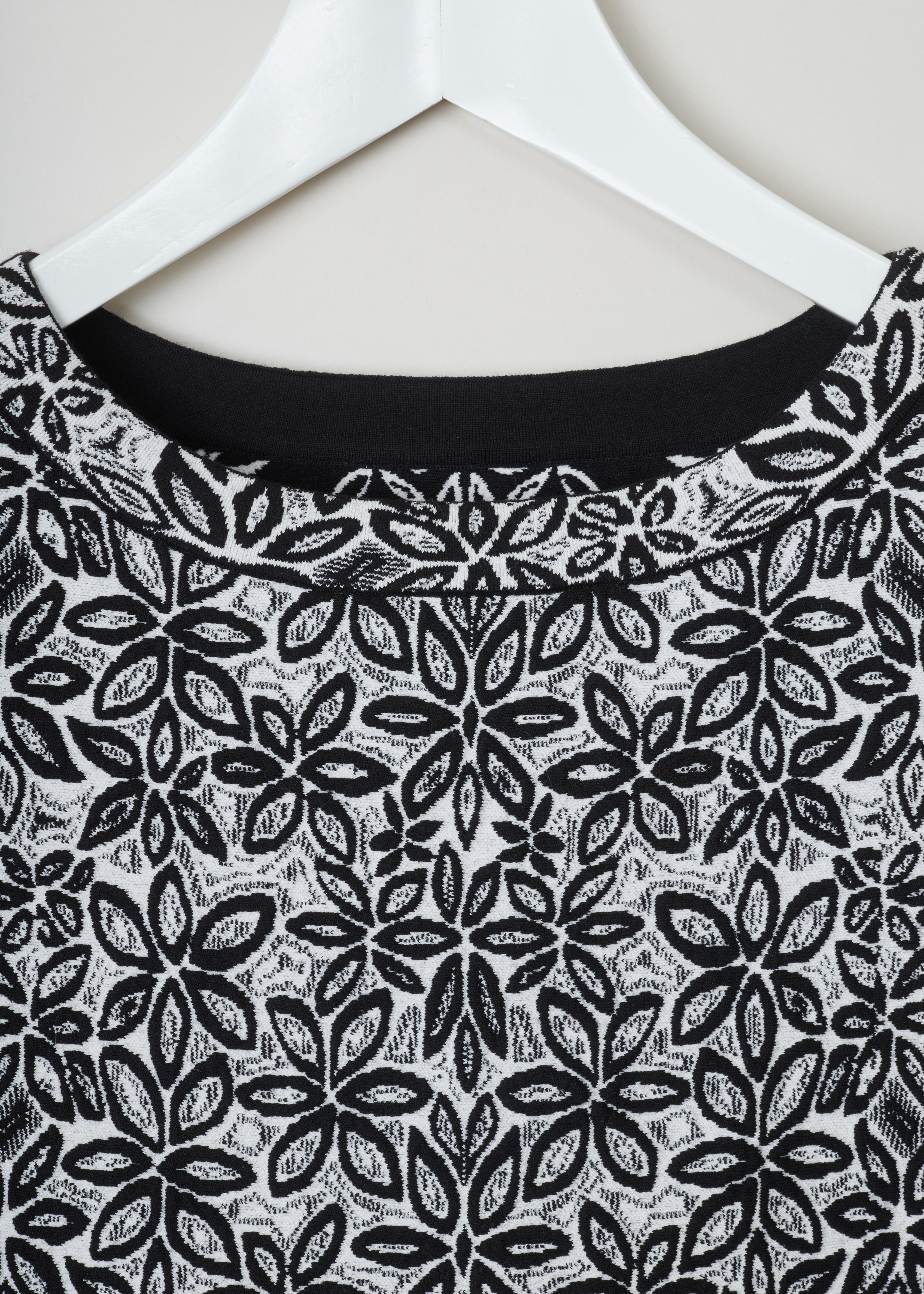 Alaïa, Wool-blend tunic with a flower pattern, 7W9UE52RM353_TUNIQUE_ADENIUM_C009_Blanc/Noir, Grey, Print, Detail, Jacquard knitted tunic with a black and white flower motif. The dress has short sleeves, a wide round neckline, an A-line silhouette and scalloped hems.

