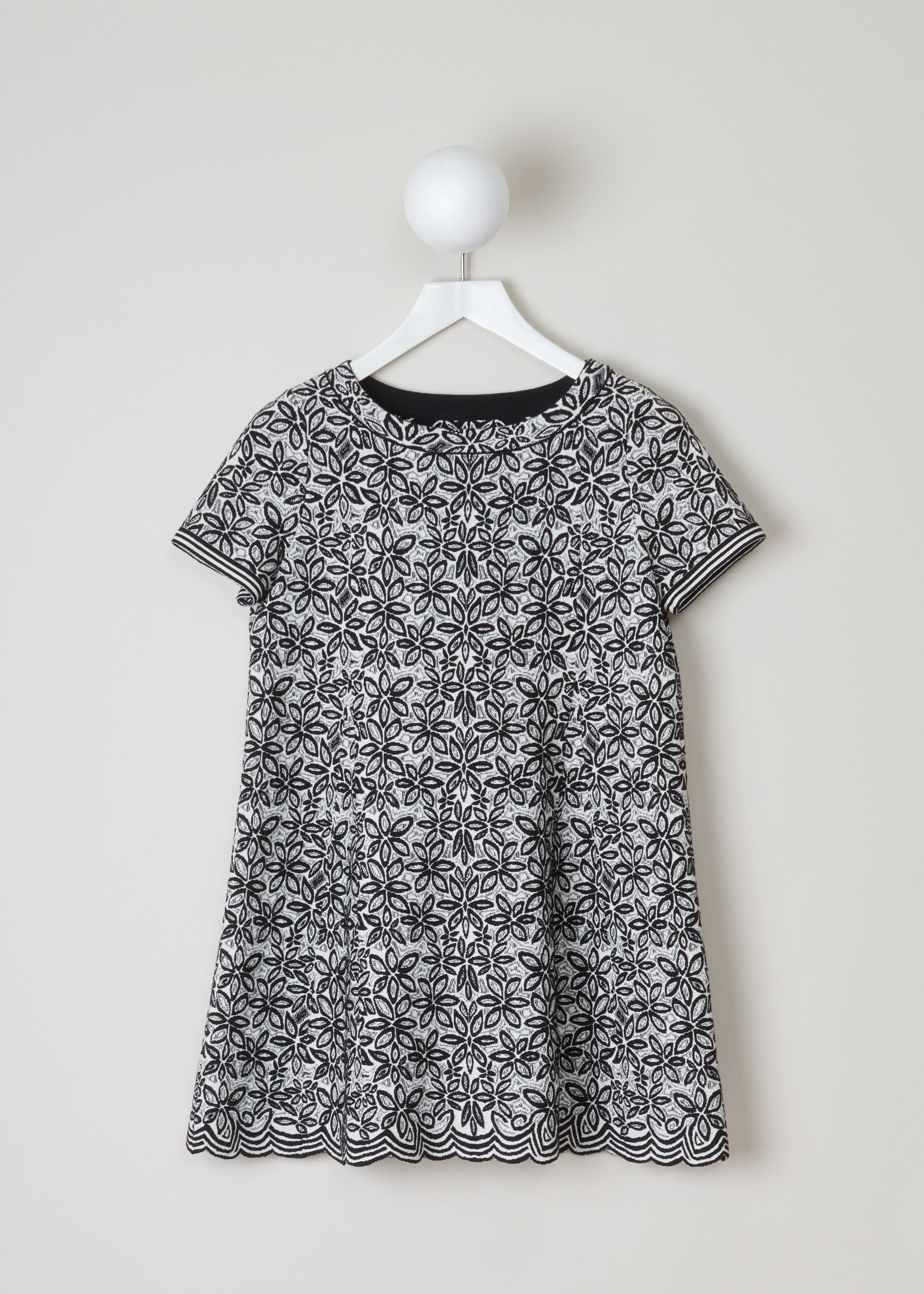 Alaïa, Wool-blend tunic with a flower pattern, 7W9UE52RM353_TUNIQUE_ADENIUM_C009_Blanc/Noir, Grey, Print, Front, Jacquard knitted tunic with a black and white flower motif. The dress has short sleeves, a wide round neckline, an A-line silhouette and scalloped hems.

