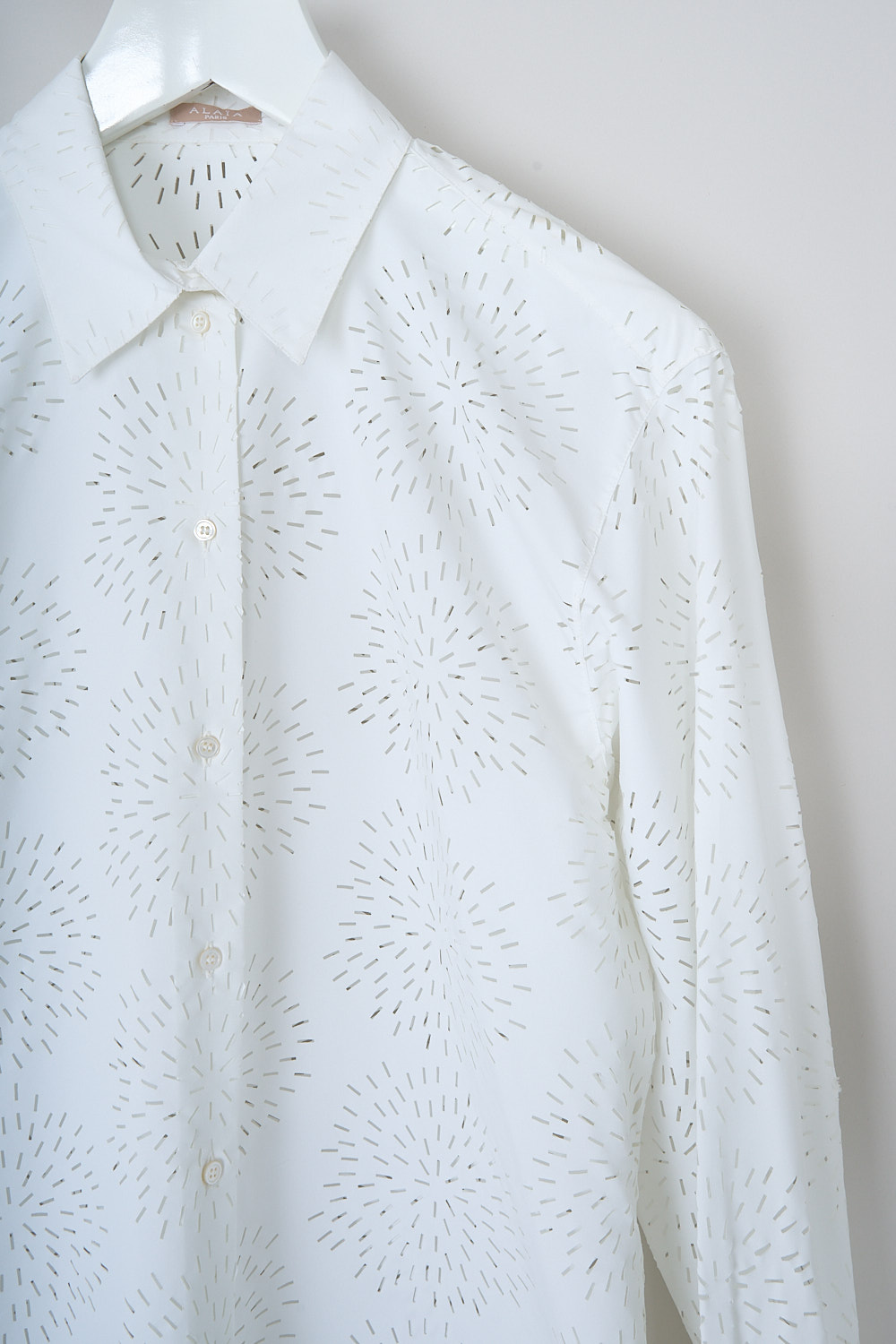 ALAÏA, WHITE OPENWORK FEU D'ARTIFICES BLOUSE, AA9C0751RTL12_BLANC, White, Detail, This white cotton-blend blouse has a classic collar and a front button closure. The long sleeves have buttoned cuffs. The blouse has a openwork pattern throughout. The blouse has a slightly rounded hemline. 
