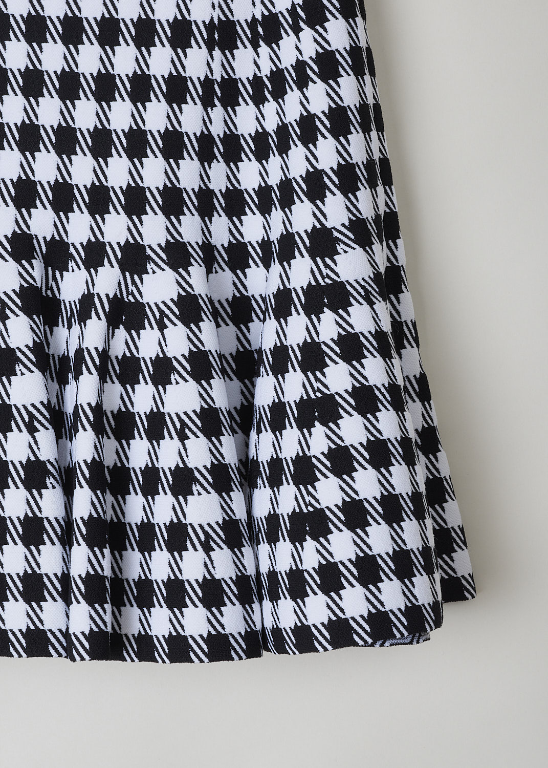 ALAÏA, FIT-AND-FLARE HOUNDSTOOTH MINI SKIRT, Black, White, Print, Detail, This fit-and-flare mini skirt has a magnified black and white Houndstooth print throughout. The skirt sits high on the waist and flares out. A concealed side zip functions as the closure function. The skirt is fully elasticated.

