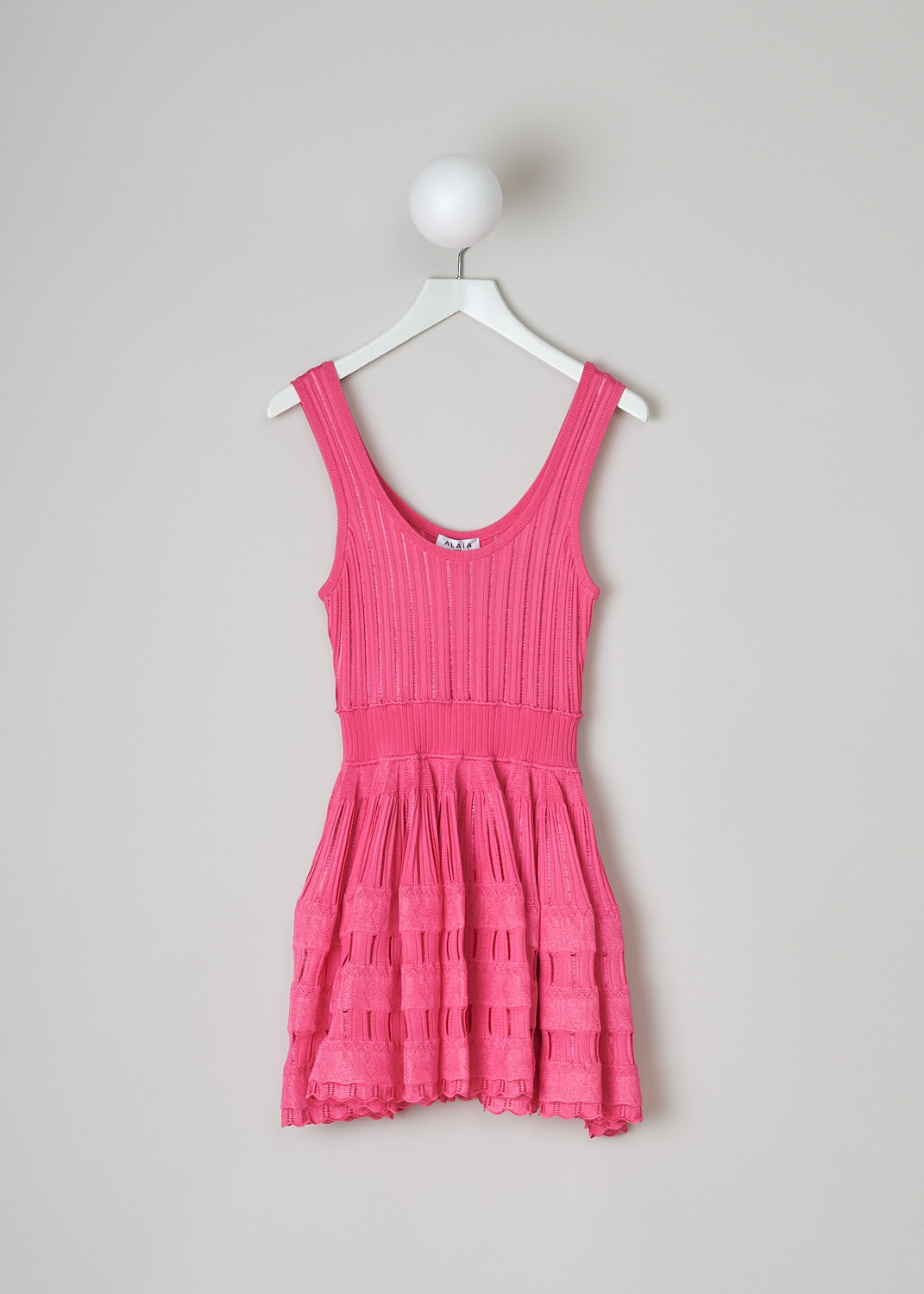 ALAÏA, FLUID SKATER DRESS IN FUCHSIA, AA9R22462M712_426_fuchsia, Pink, Front, This sleeveless skater dress in fuchsia pink has a scooped U-neckline. The slip-on dress has a fitted bodice with vertical openwork trims, giving it a ribbed look. A broad elastic waistband divides the bodice from the voluminous mini skirt. The crinoline-like skirt has intricate openwork and lace trims. The dress has a scalloped hemline.  
