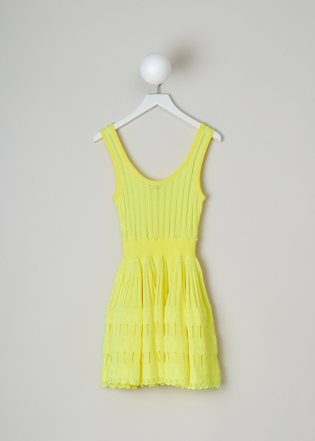 ALAÏA, FLUID SKATER DRESS IN FLUORESCENT YELLOW, AA9R22462MM712_JAUNE_FLUO, Yellow, Back, This sleeveless skater dress in fluorescent yellow has a scooped U-neckline. The slip-on dress has a fitted bodice with vertical openwork trims, giving it a ribbed look. A broad elastic waistband divides the bodice from the voluminous mini skirt. The crinoline-like skirt has intricate openwork and lace trims. The dress has a scalloped hemline. 
