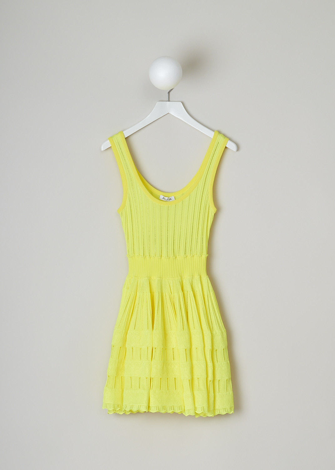 ALAÏA, FLUID SKATER DRESS IN FLUORESCENT YELLOW, AA9R22462MM712_JAUNE_FLUO, Yellow, Front, This sleeveless skater dress in fluorescent yellow has a scooped U-neckline. The slip-on dress has a fitted bodice with vertical openwork trims, giving it a ribbed look. A broad elastic waistband divides the bodice from the voluminous mini skirt. The crinoline-like skirt has intricate openwork and lace trims. The dress has a scalloped hemline. 
