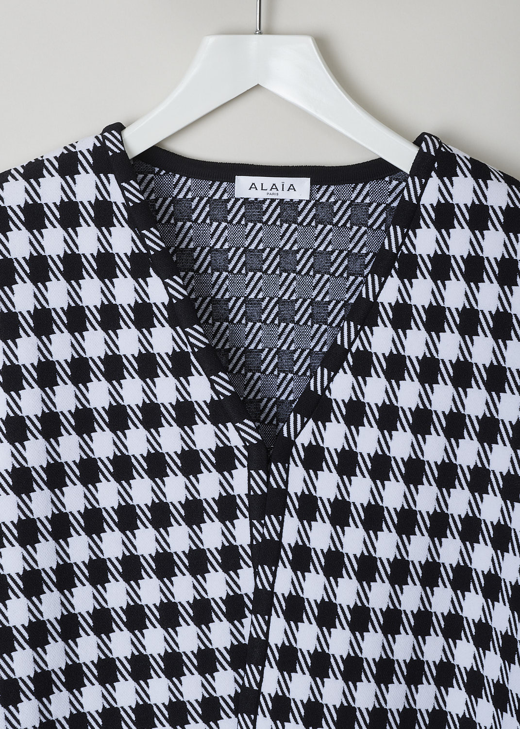 ALAÏA, CROPPED HOUNDSTOOTH PRINTED JACKET, AA9V10432M710_HOUNDSTOOTH_991, Black, White, Print, Detail, This long sleeve jacket has a magnified black and white Houndstooth print throughout. The jacket has a cropped length, with the hem falling to the hip. The jacket has an open front with just a single hook-closure on the V-necks end. The jacket has shoulder pads.


