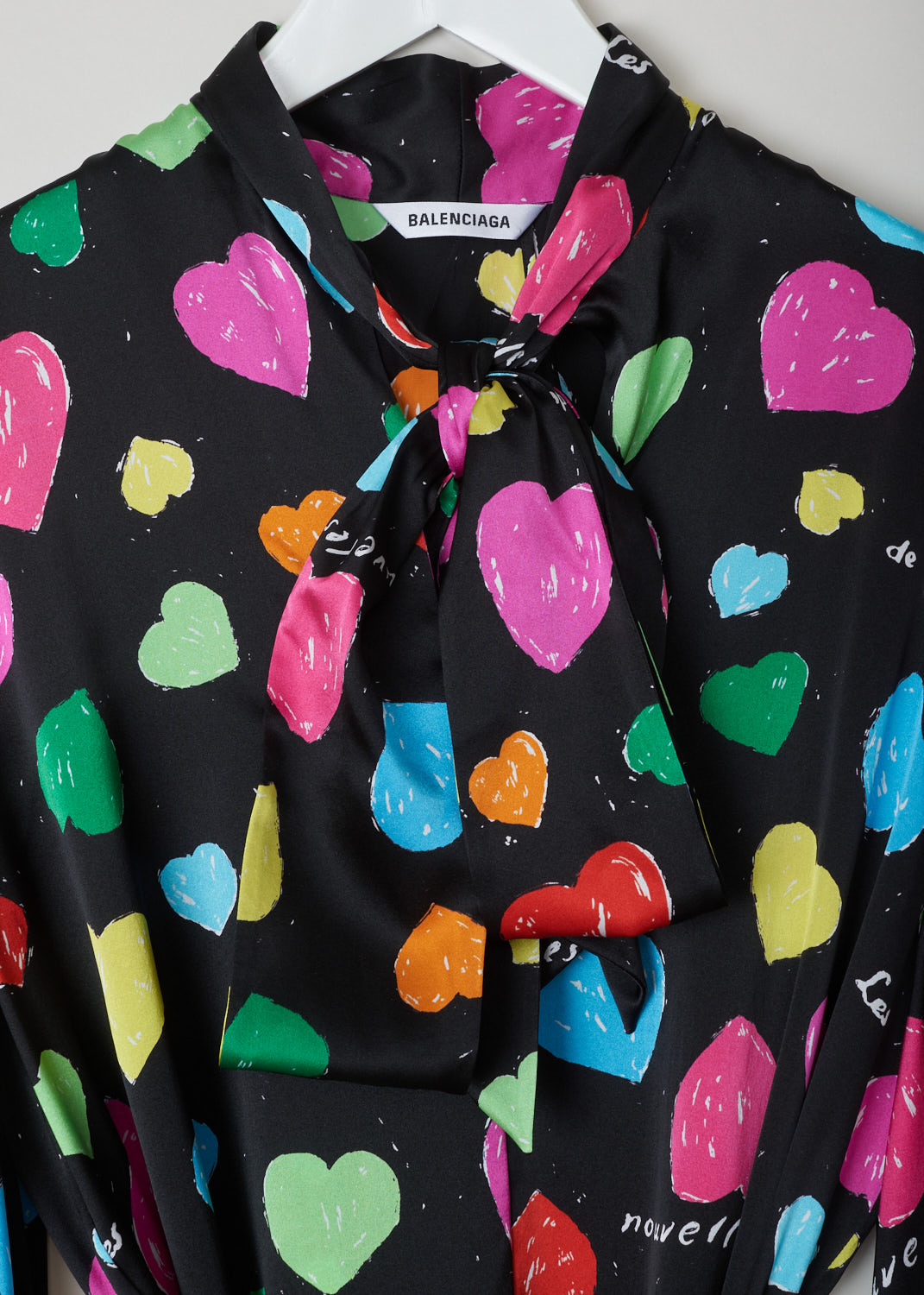 Balenciaga, Archive hearts print blouse, WL0_659088_TKL08_1000, black, pink, green, yellow, blue, print, detail 1, This blouse features an archive hearts and text print which stands out against the black silk background. It has a self tie collar and a belted waist. The blouse also has long sleeves with elasticated cuffs. 
