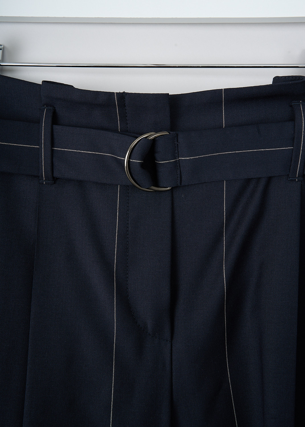 Brunello Cucinelli, Navy blue pants with white pinstripe, M0H36P6249_C6009, Blue, Print, Detail, These navy blue pinstripe pants have a broad waistline with belt loops. These pants include a D-ring belt made in the same fabric. A concealed clasp and zipper functions as the closure option. The slightly tapered pant legs have centre creases. Slanted pockets can be found in the front and welt pockets in the back. 
