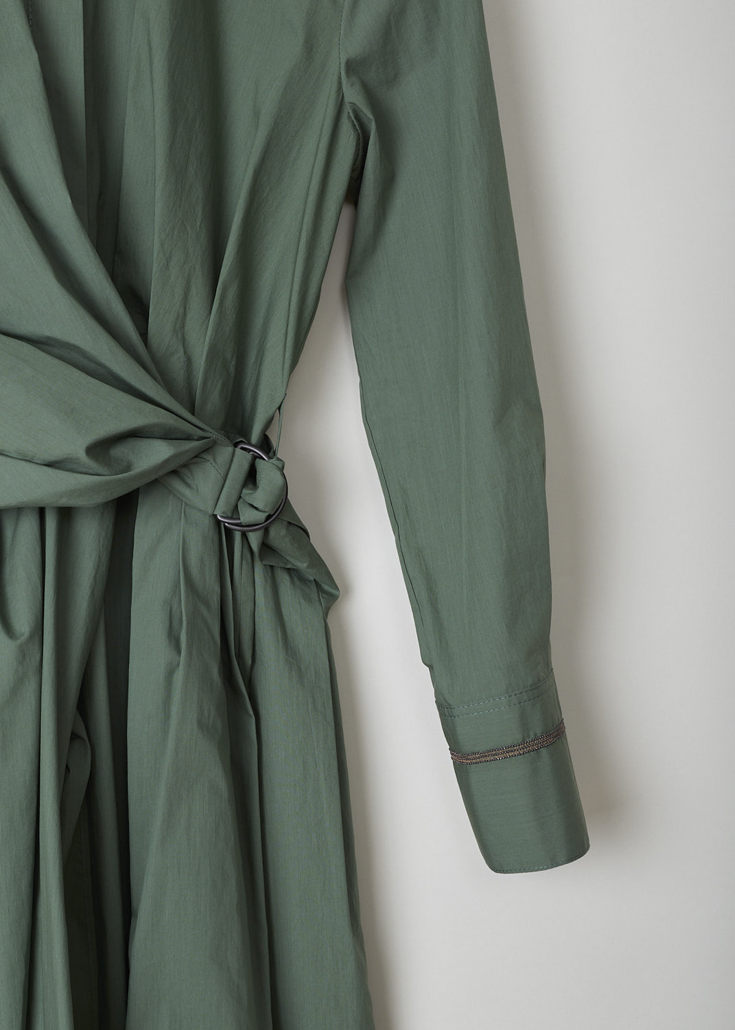 BRUNELLO CUCINELLI, GREEN SHIRT DRESS WITH WRAP DETAIL, M0H93A4873_C8625, Green, Detail 1, This green midi shirt dress has a classic collar and concealed front button closure that goes down to the waistband. The waistband is elasticated at the back. The waist is accentuated by the wrap detail, that goes around like a belt and is fastened to one side with the metal buckle. The long sleeves have buttoned cuffs and are decorated with a monili beaded trim.
