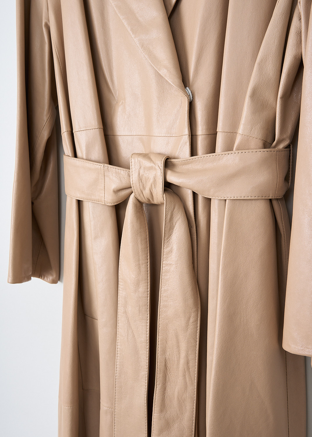 Brunello Cucinelli, Beige double-breasted leather coat, MPBIS9356_C7689, Beige, Detail, This beige double-breasted wrap coat has a notched lapel and a concealed press stud closure. The long sleeves have a straight hem. A matching leather belt can be used to cinch in the waist.  In the front, the coat has slanted pockets. The coat has a straight hemline. 
