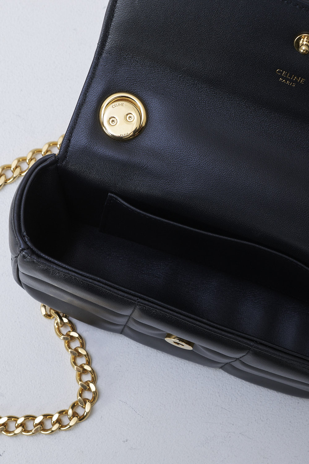 CELINE, BLACK MATELASSÉ MINI CHAIN SHOULDER BAG, 10L333EWJ_38NO, Black, Detail 1, This black matelassé mini shoulder bag has gold-tone metal hardware with the brand's lettering on the front and a gold chain shoulder strap. The bag has a snap button closure. The flap opens to the main compartment with a inner pocket to the backside.  
