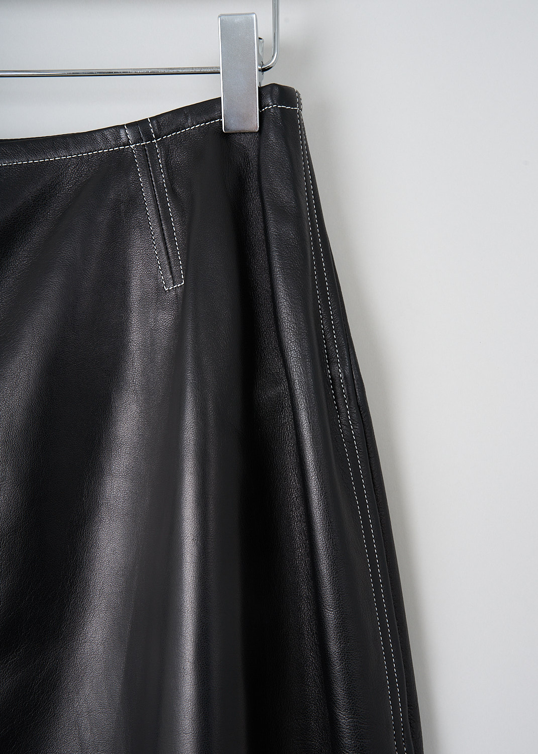 Celine, Flared black leather skirt, 6828_22N21_0N0, Black, Detail, This flared black leather skirt has an A-line silhouette. A concealed centre zip in the back functions as the closure. The skirt has concealed slanted pockets. Contrasting white stitching has been used throughout. 
