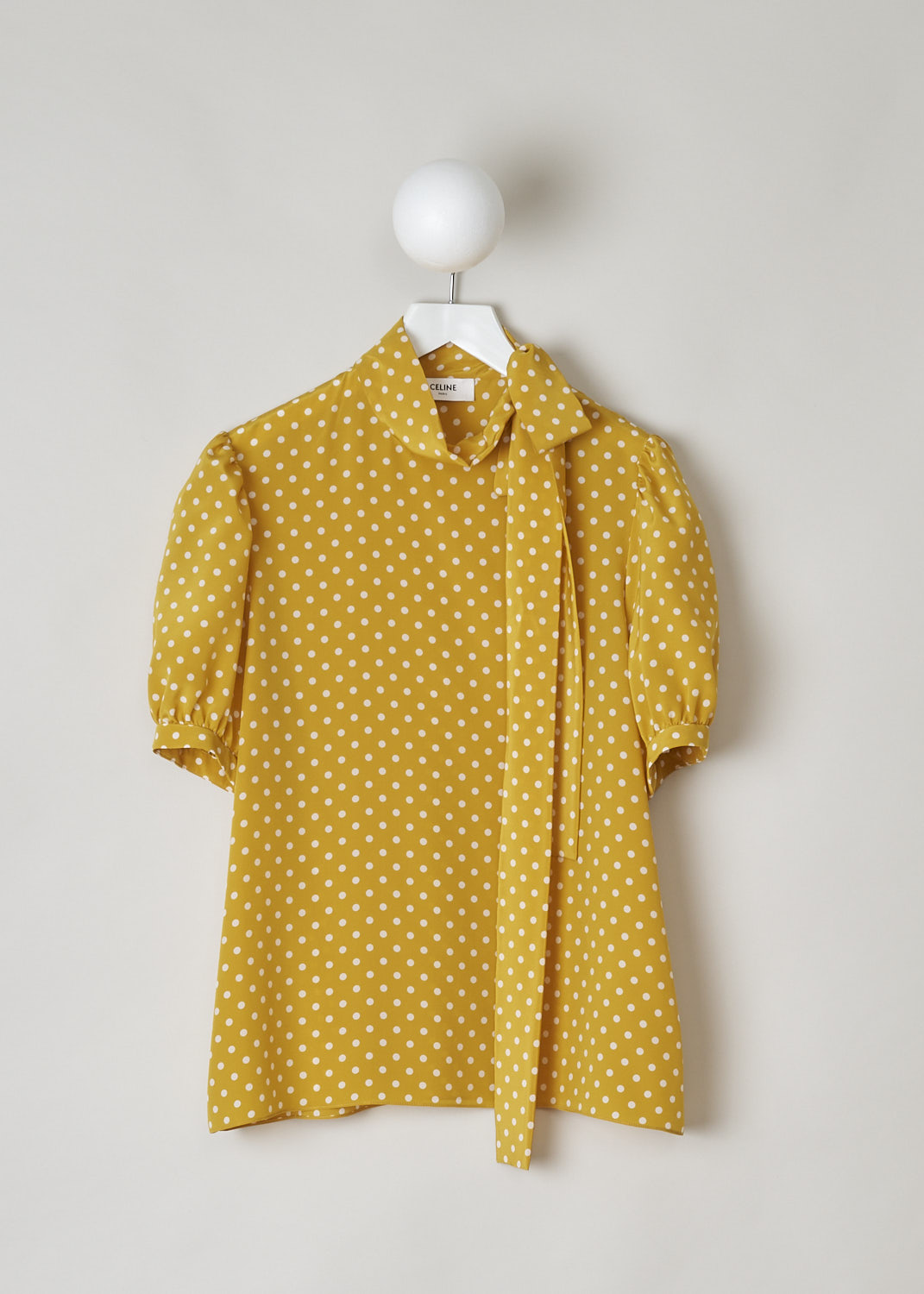 CELINE, MUSTARD YELLOW POLKA DOT TOP WITH PUSSY BOW, 966H_2B606_11TC, Yellow, Print, Front, This mustard yellow top has a white polka dot print. The top has a high neck with a pussy bow to one side. The top has short puff sleeves. The closure option is a concealed zipper on the left shoulder.   
