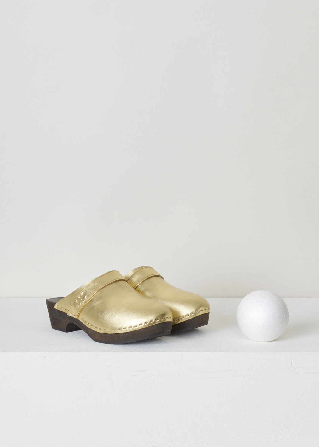 CELINE, METALLIC GOLD CLOGS, 337753093C_35OR, Gold, Front, These regal metallic gold clogs have a rounded nose. This slip-in model has a broad, wood-style sole with a small heel. Across the width of the shoe, a small strip with the Celine Triomphe logo can be found. 


Heel height: 3 cm / 1.18 inch

