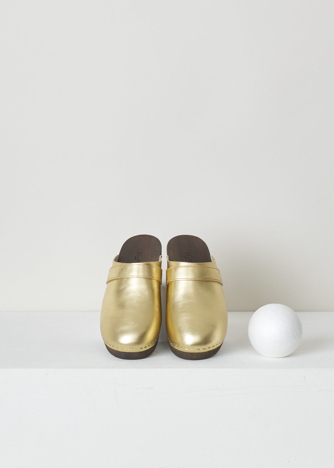 CELINE, METALLIC GOLD CLOGS, 337753093C_35OR, Gold, Top, These regal metallic gold clogs have a rounded nose. This slip-in model has a broad, wood-style sole with a small heel. Across the width of the shoe, a small strip with the Celine Triomphe logo can be found. 


Heel height: 3 cm / 1.18 inch
