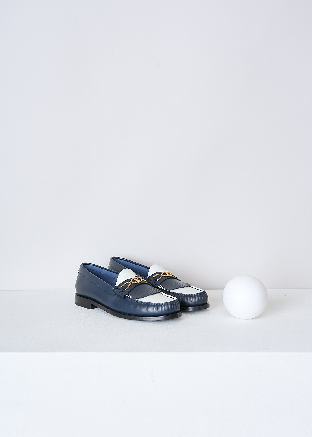 CELINE, TWO-TONE LEATHER LOAFERS, 337773001C_07NJ, White, Blue, Front, These two-tone leather loafers in navy and white have a round toe with  fringed tassels and a gold-tone buckle with the brand's logo on the vamp. Around the trim, the leather is subtly pleated.


