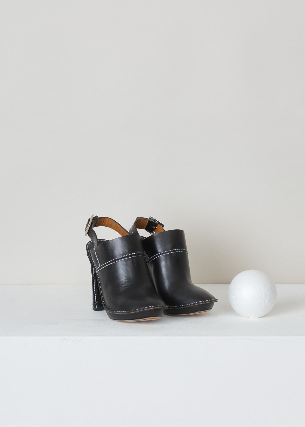 ChloÃ©, Black clog mule with white stitching, CH25041_10ASW_L5L7_999_black, white, front, These black clog mules feature a round toe, slip-on design and a buckle to tie around anckle. The contrasting white stitching adds charm to these clog mules.

Heel height: 11,5 cm / 4.33 inch
