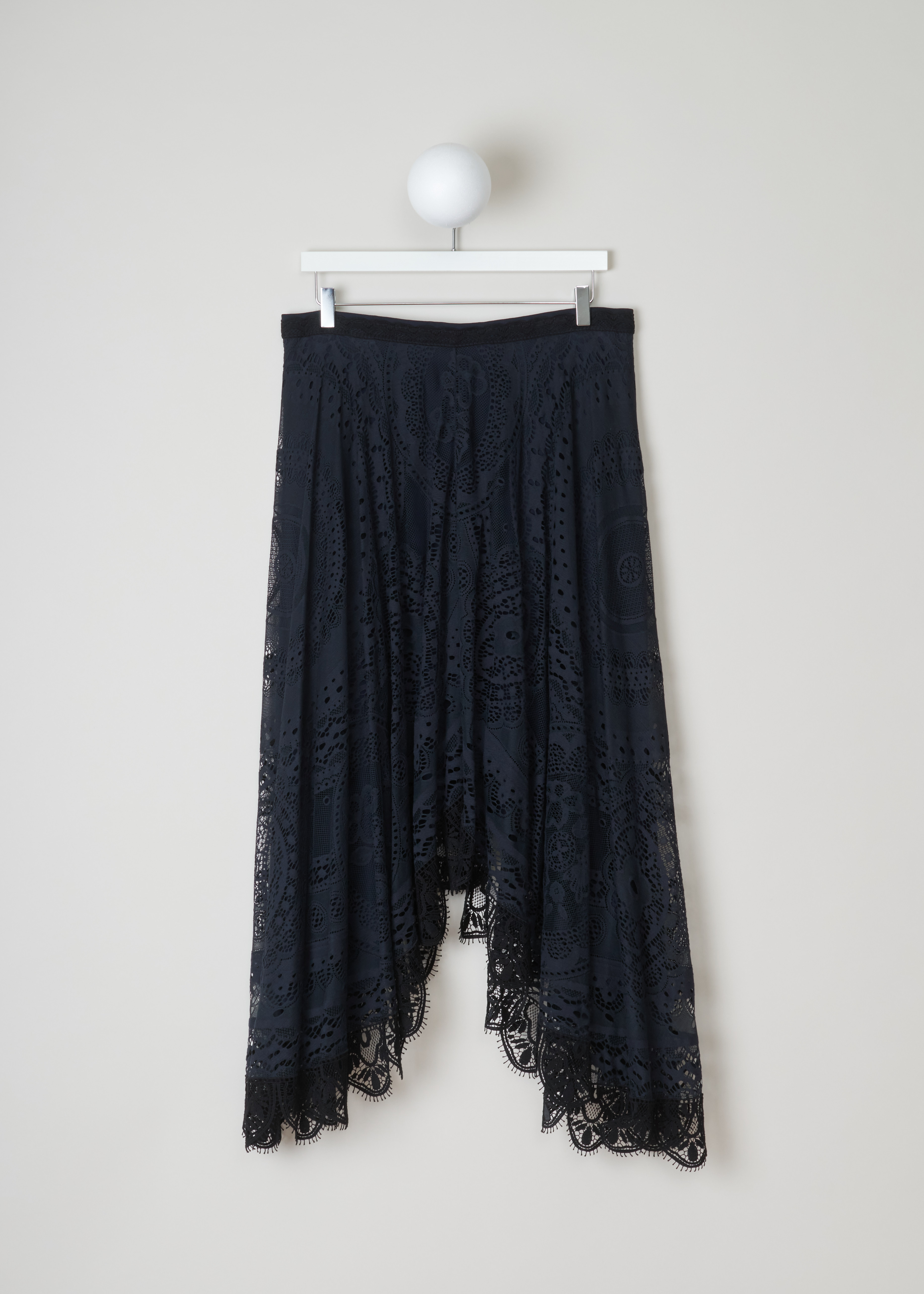 Chloé, Navy lace skirt in an asymmetric model, CHC18SJU0540448A_48A_iconic_navy, blue, front. Lace skirt in navy, cut to an asymmetric model. It has a concealed zipper on the back and frilled hem. The skirt has a slim waist band and a wide fit which causes the skirt to pleat all-round. 