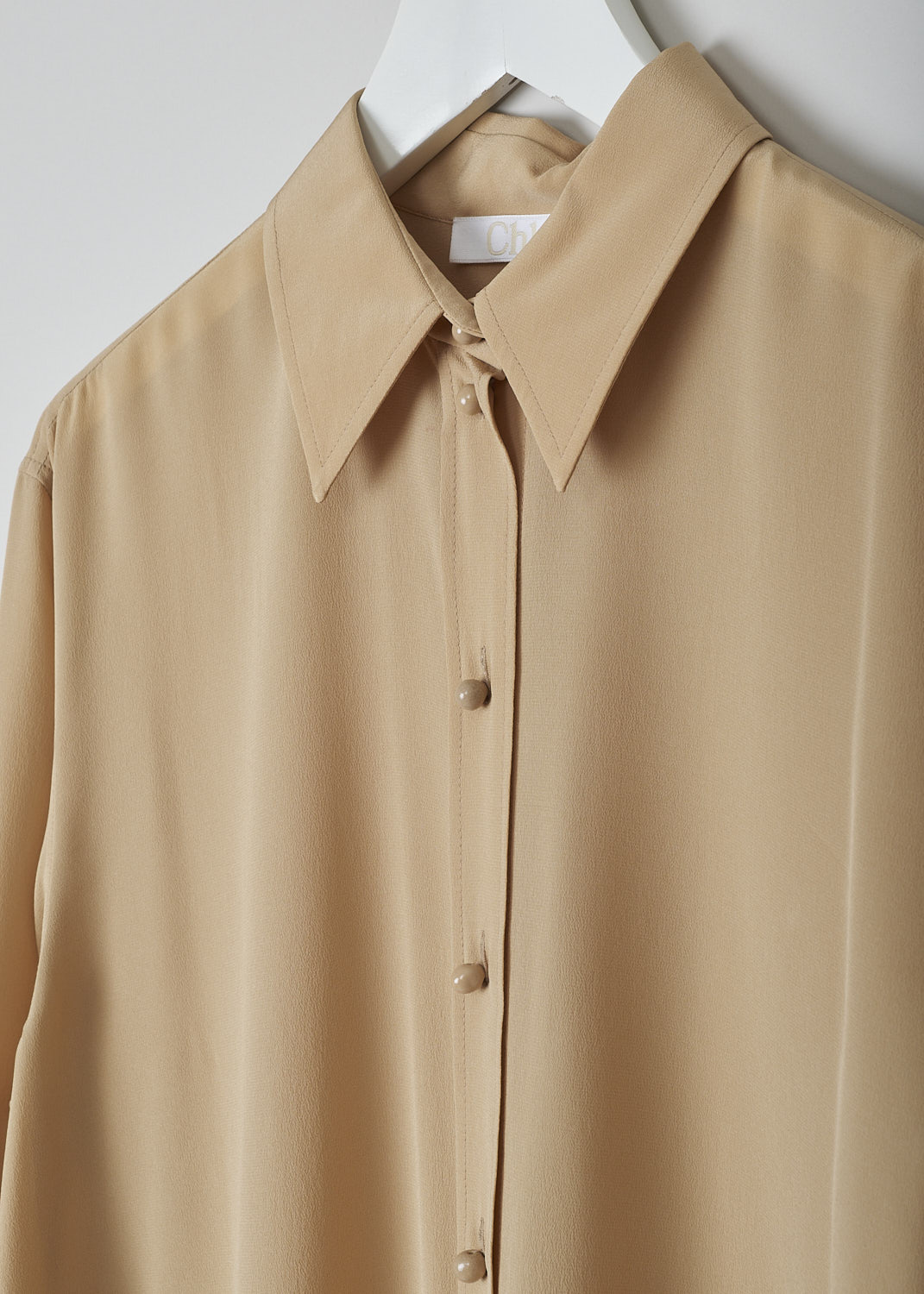 CHLOÉ, PEARL BEIGE BLOUSE, CHC22UHT05004278, Beige, Detail, This silk pearl beige blouse has a classic collar and a button placket with round ceramic. The blouse has long sleeves with buttoned cuffs.  A centre box pleat runs vertically down the back.
