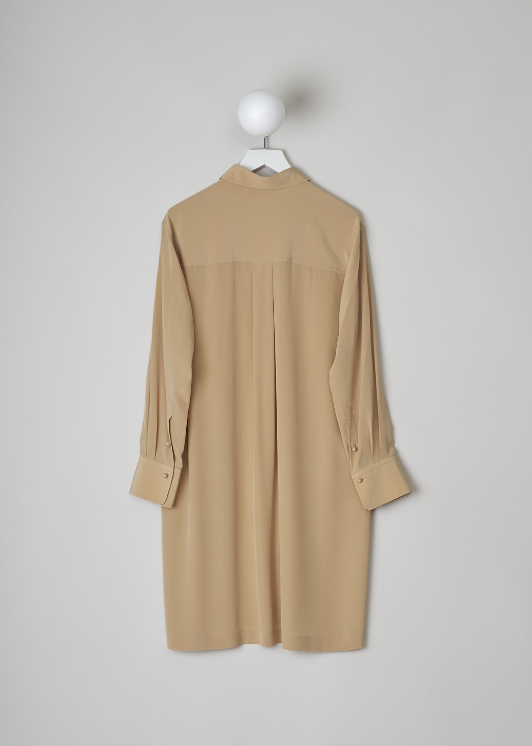CHLOÉ, PEARL BEIGE SILK SHIRT DRESS, CHC22URO64004278, Beige, Back, This pearl beige silk dress has a classic collar and a button placket with round ceramic buttons that go halfway across the chest. Below the placket, a single knife pleats goes down to the hemline. This loose fitted dress has long sleeves with buttoned cuffs. Slanted pockets are concealed in the side seam. The dress has side slits and an asymmetrical finish, meaning the back is a little longer than the front. A centre box pleat runs vertically down the back.
