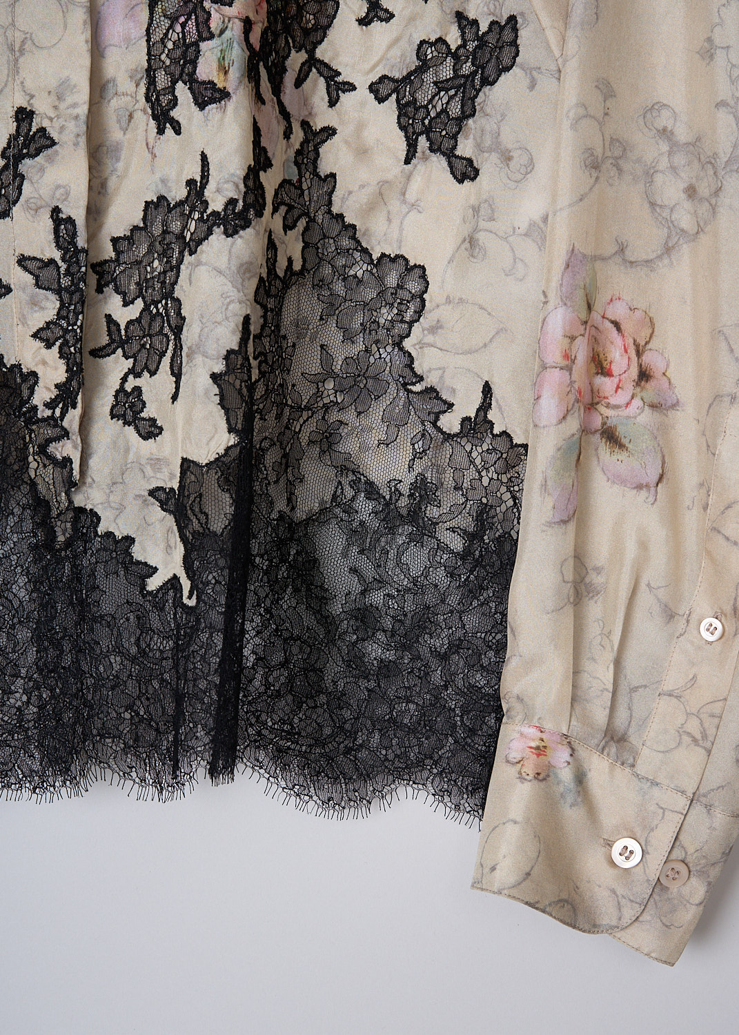 DRIES VAN NOTEN, SILK FLORAL BLOUSE WITH BLACK LACE DETAILING, Beige, Print, Black. Detail, This long sleeve beige silk blouse has a muted floral print with pink accents. The black floral lace hem snakes up along the front. The blouse has a pointed collar and a front button closure. The long sleeves have buttoned cuffs. 
