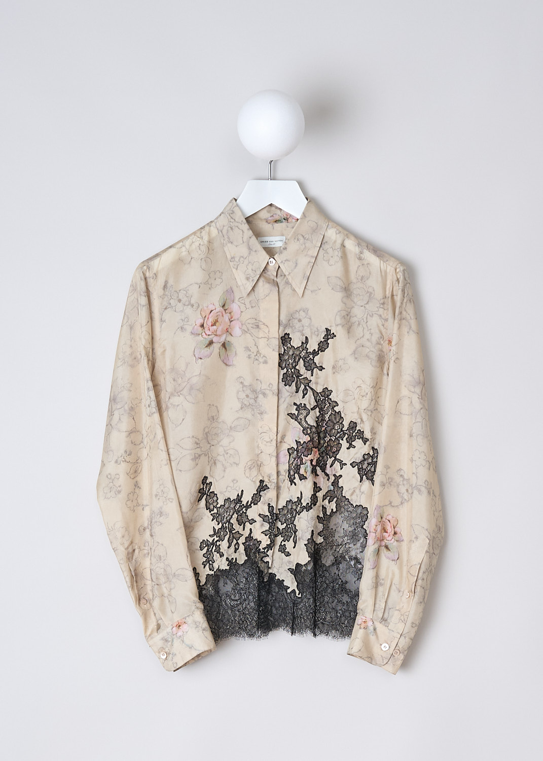 DRIES VAN NOTEN, SILK FLORAL BLOUSE WITH BLACK LACE DETAILING, Beige, Print, Black. Front, This long sleeve beige silk blouse has a muted floral print with pink accents. The black floral lace hem snakes up along the front. The blouse has a pointed collar and a front button closure. The long sleeves have buttoned cuffs. 
