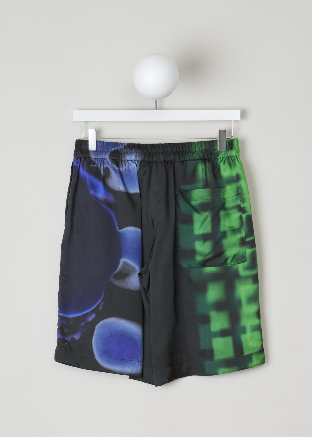 Dries van Noten, Sporty shorts, POMAR_LONG_2068_WW_PANTS_GRE, black green print, back, Viscose twill shorts, decorated with a graphic print coloured in blue, green and a splash of purple. Featuring an elastic waistband with a drawstring. Furthermore, this model comes with a high-waist and loose fit, concealed pockets can be found on the side seam and has a single jetted pocket on the back.