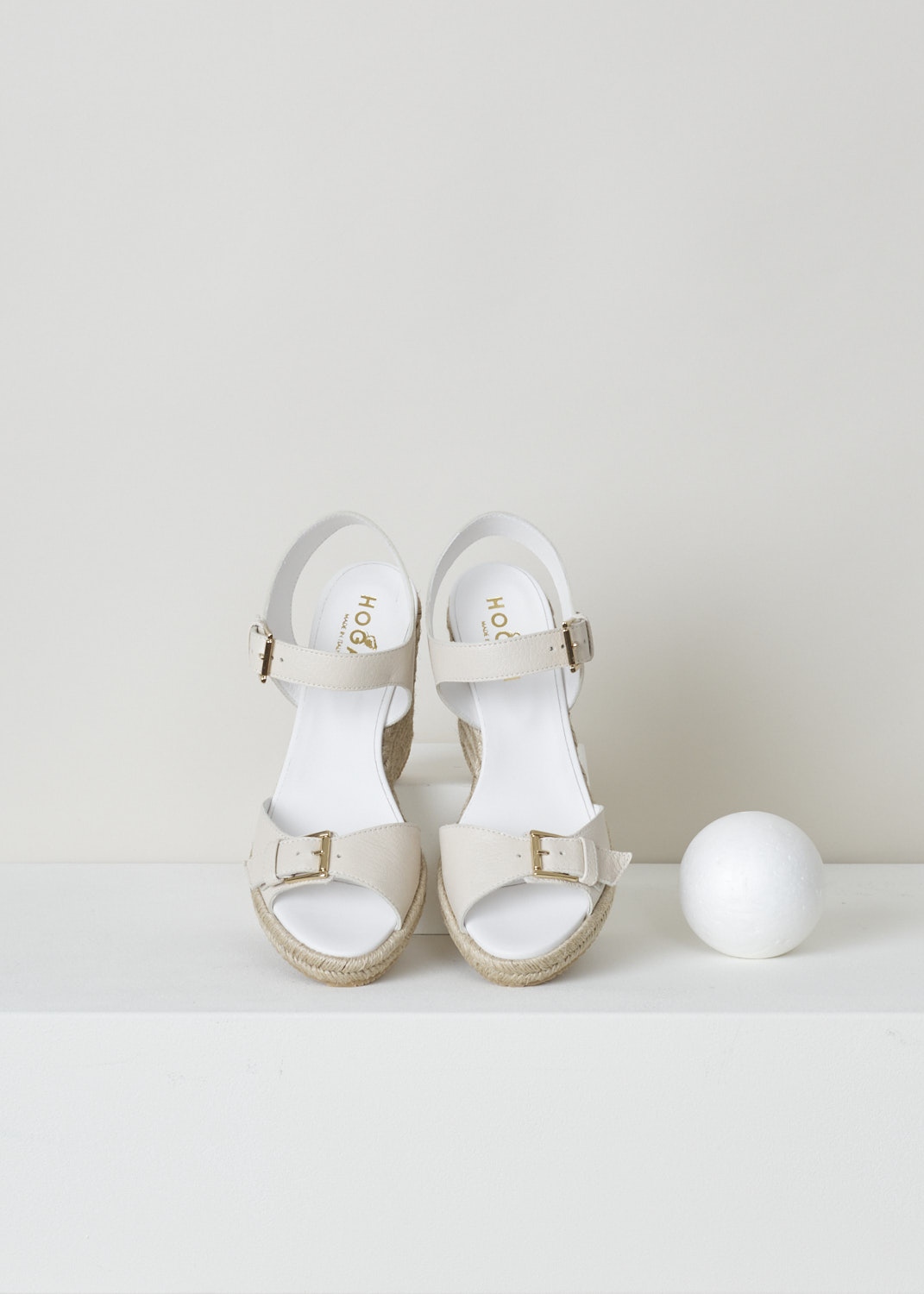 Hogan, Wedge heeled sandals in beige, HXW5580DL20P7KB018_H558_P7K, beige, top, These lovely cream coloured wedge heeled sandals fills us all with summer vibes. Featuring a single strap over the vamp with an gold-tone ornamental buckle. The ankle strap however, has a functional buckle which acts as your fastening option. 

Heel height: 11 cm / 4.3 inch. 