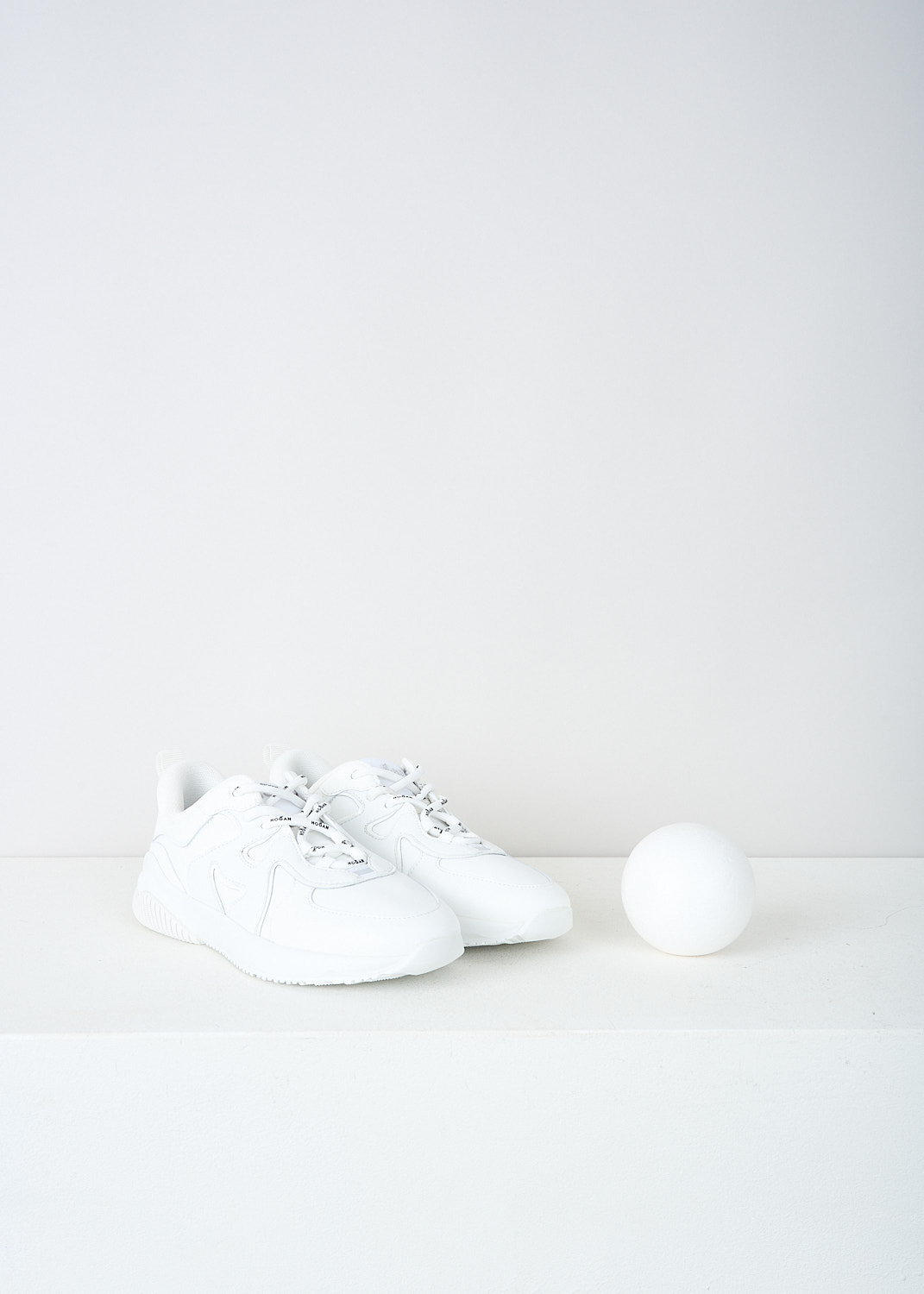 Hogan, All-white H597 sneakers, HXW5970EA90RF8B001, White, Front, These all-white low top H597 sneakers feature front lace-up fastening with white laces that have the brand's name printed on them in black. The brand's H logo is incorporated into the design on the sides. The sneakers have white rubber soles.  
