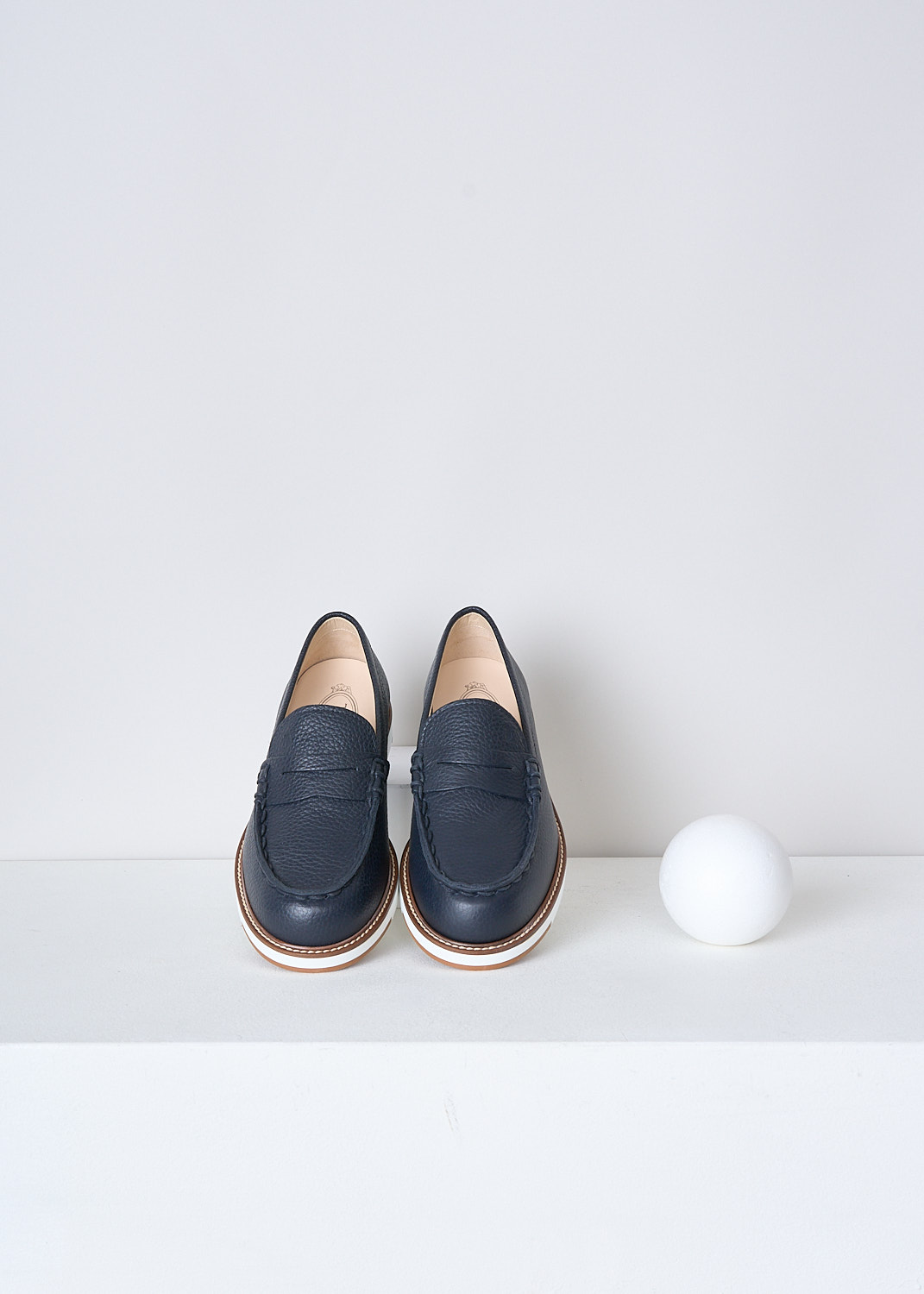 TODS, DARK BLUE GRAINED LEATHER PENNY LOAFERS, XXW05E0EB60EK0U801, Blue, Top, These dark blue grained leather penny loafers have a almond toe and a decorative slotted leather strip over the upper side. The loafers have white soles with a beige trim and light stitching. The brand's logo has been subtly embossed on the front


