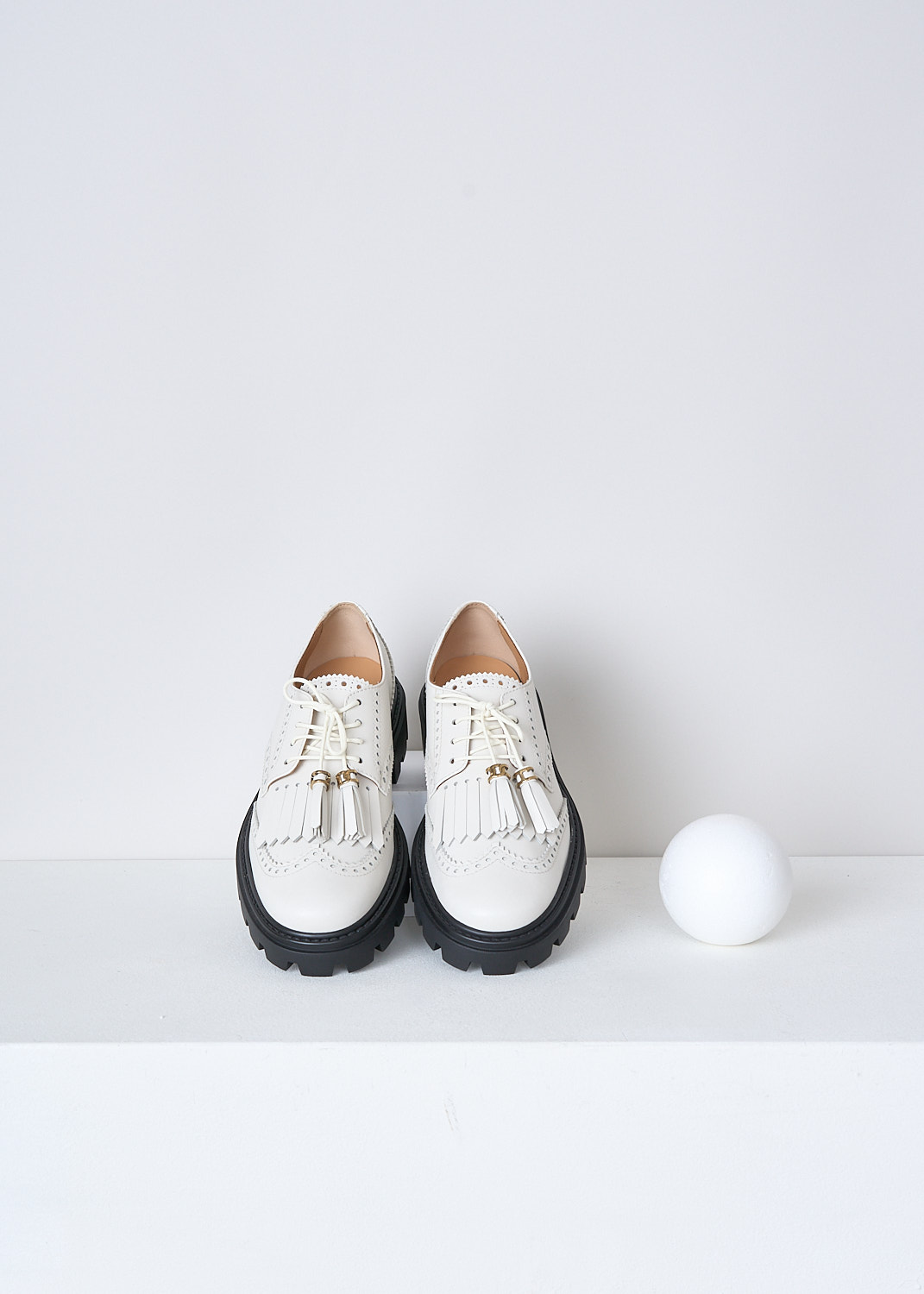 TODS, OFF-WHITE LOAFERS WITH TASSELS, XXW08J0HO10RBTB015, White, Top, These off-white leather derby shoes have a front lace-up closure. The off-white laces have tasseled tips. These shoes have a round toe with fringes across the vamp. Classic perforation detailing extends along the entire shoe. These shoes have a ridged black sole.


