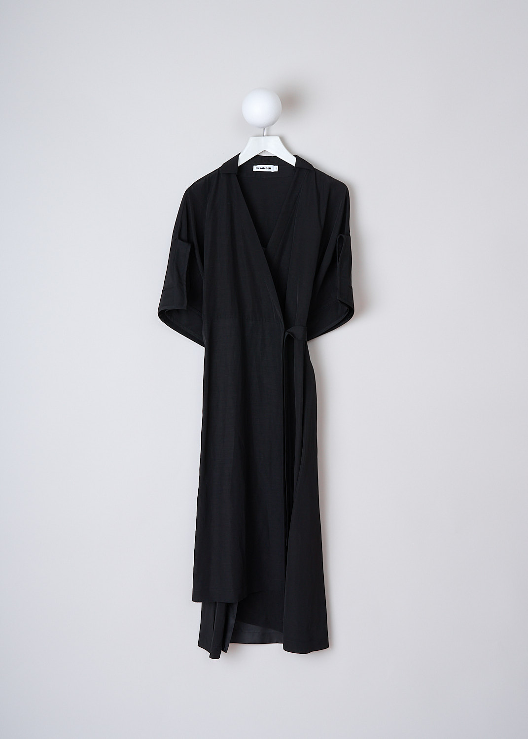 JIL SANDER BLACK GALATEA WRAP DRESS, JSWO509255_W0390500D_001, Black, Front, This black midi wrap dress with three-quarter length sleeves with oversized buttoned cuffs. The dress has a cutaway-collar and a V-neckline. To on side, a single slanted pockets is concealed in the side seam. On the other side, the dress has a side slit. The dress features an inner attached slip dress. The dress has a straight hemline.
 
