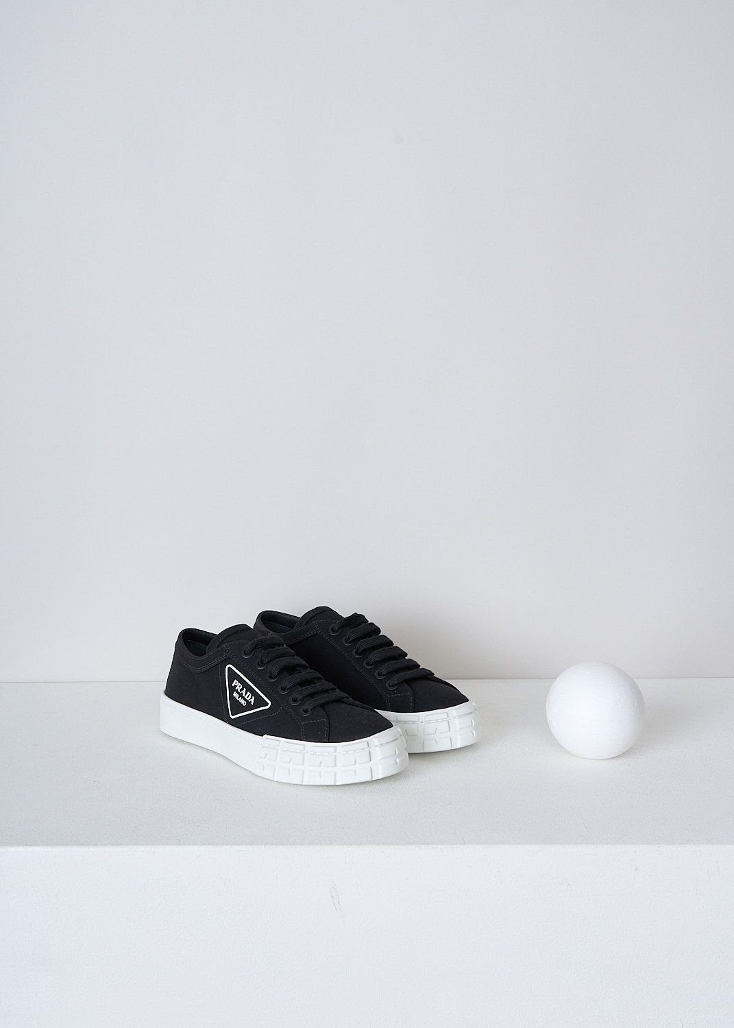 PRADA, BLACK CANVAS SNEAKERS WITH WHITE SOLE, GUD_GABARDINE_1E939I_F0967_NERO_BIANCO,  Black, Front, These low top black canvas sneakers feature a front lace-up fastening with black laces. The brand's triangle logo can be found on the side in white. These sneakers have a round toe with a white rubber toe cap and ribbed rubber soles.
