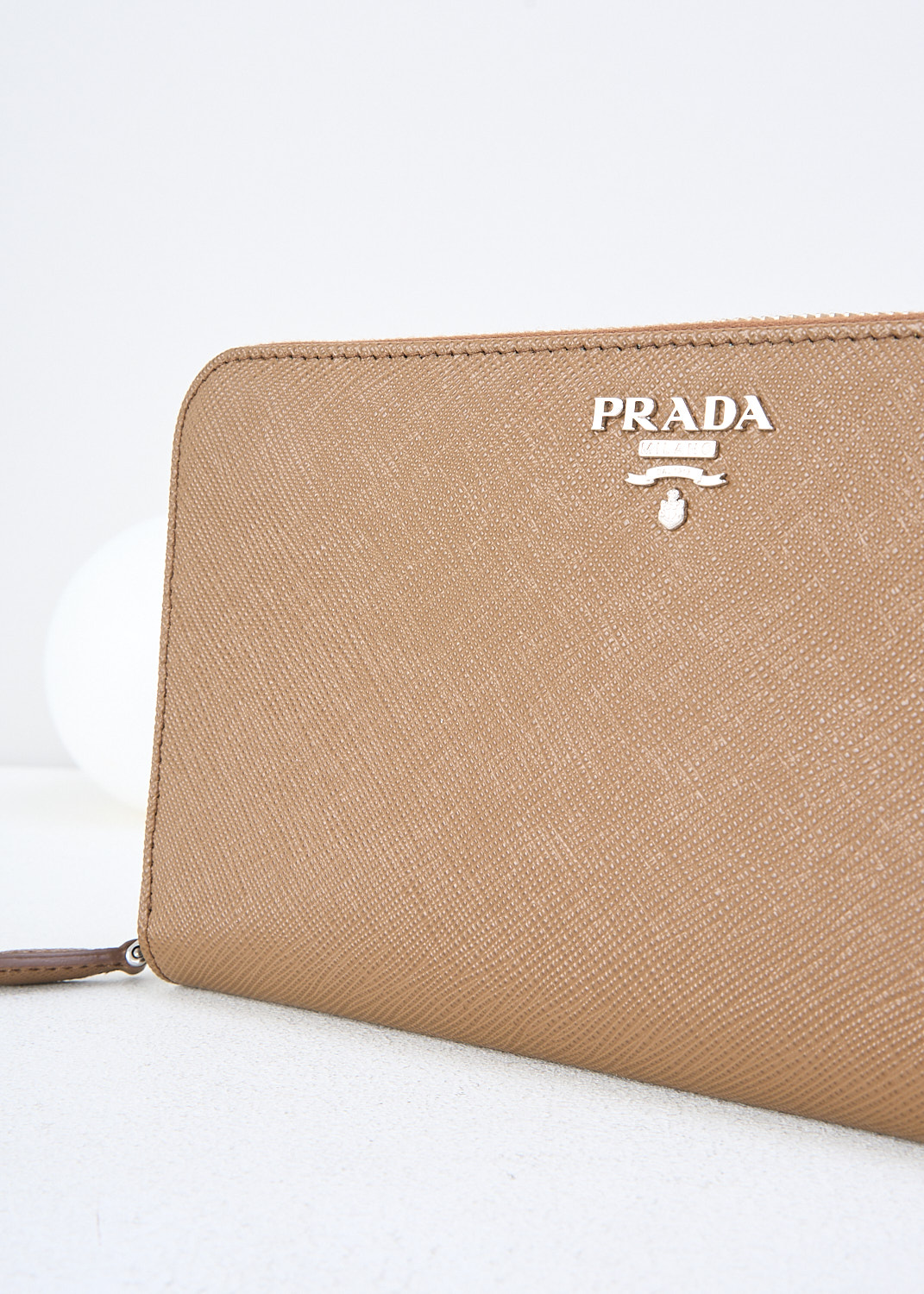 Prada, Brown leather wallet with turquoise lining, 2E6V_SAFFIANO_COLOUR_1ML506_F0NR1_CANNELLA_TURCHE, Brown, Detail, This brown Saffiano leather wallet has the brand's silver-tone metal logo on the front. The silver-tone zipper opens up to three bill compartments and a zipper coin pocket. The wallet has multiple card-slots. The wallet has a turquoise lining.