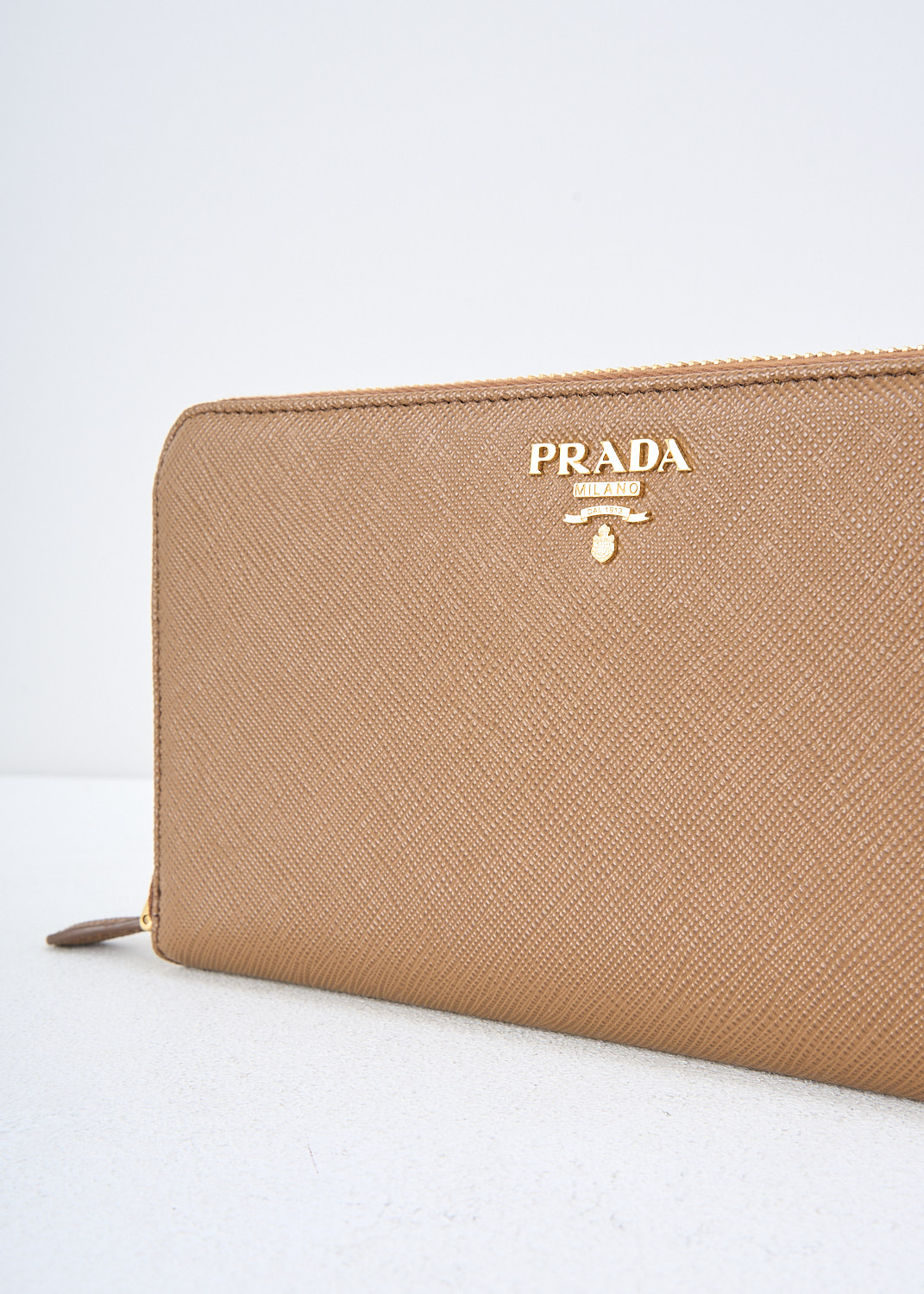 Prada, Brown leather wallet, QWA_SAFFIANO_METAL_1ML506_F0401_CANELLA, Brown, Detail, This brown Saffiano leather wallet has the brand's gold-tone metal logo on the front. The gold-tone zipper opens up to three bill compartments and a zipper coin pocket. The wallet has multiple card-slots. 

